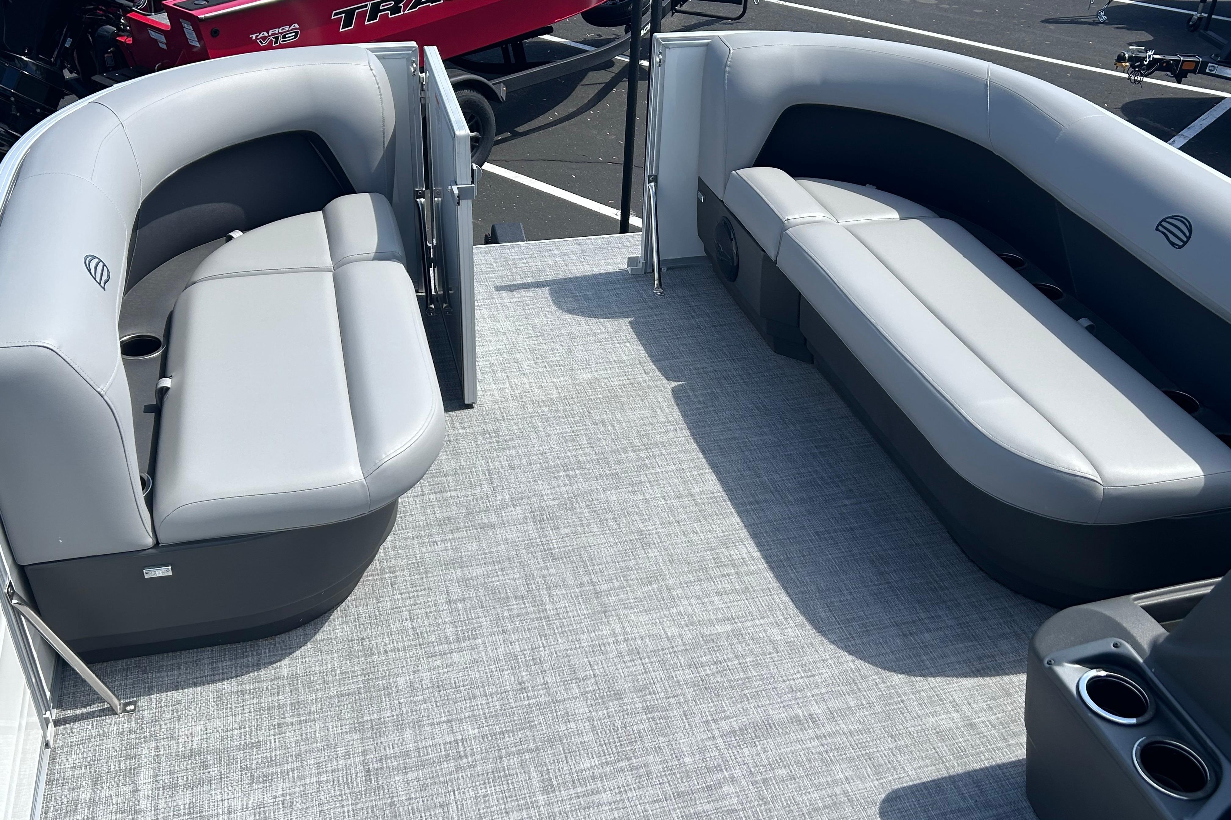 2026 Sun Tracker Party Barge 16 DLX interior with gray seating and cup holders.