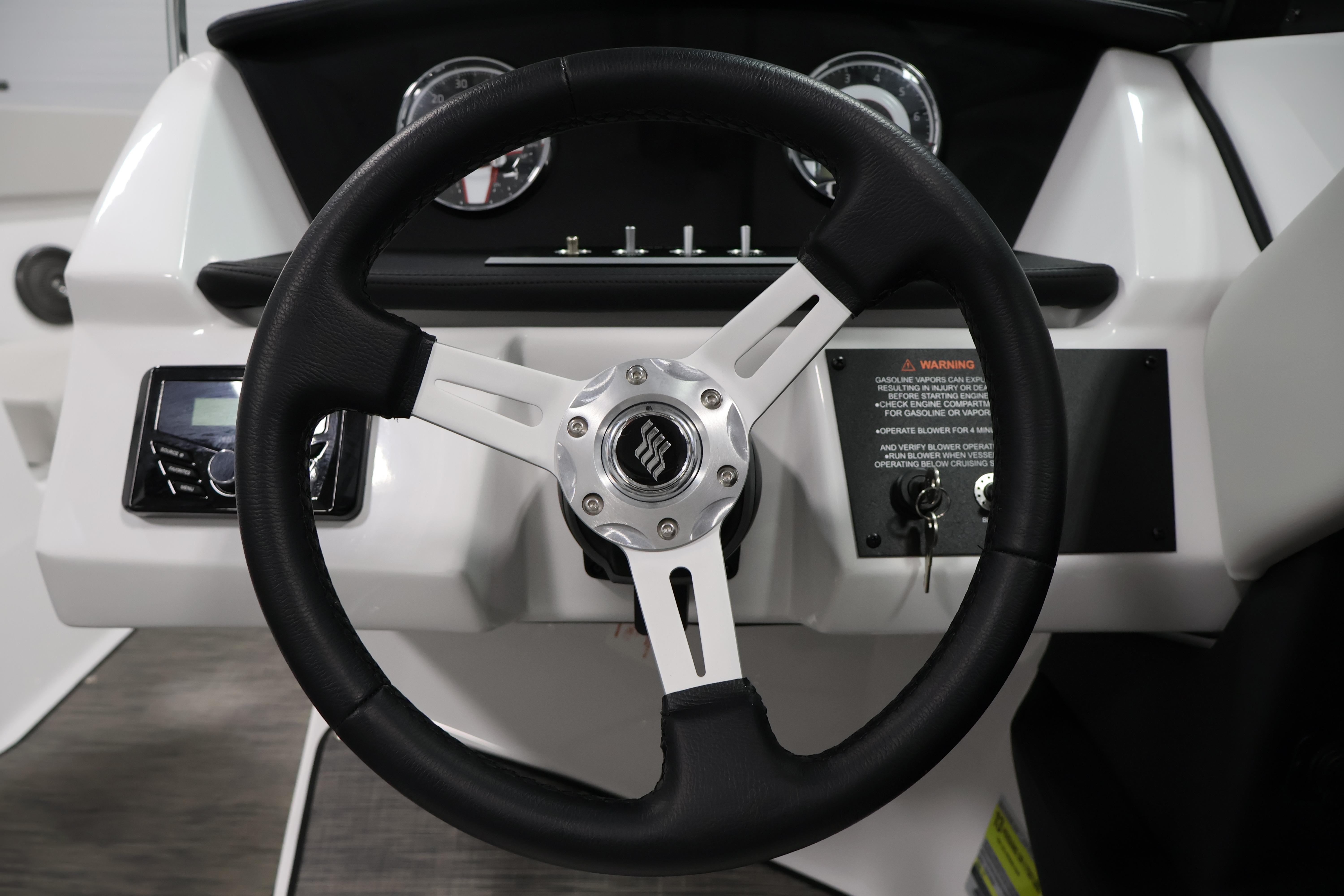 Steering wheel of 2026 Four Winns H4 Freedom boat with dashboard controls.