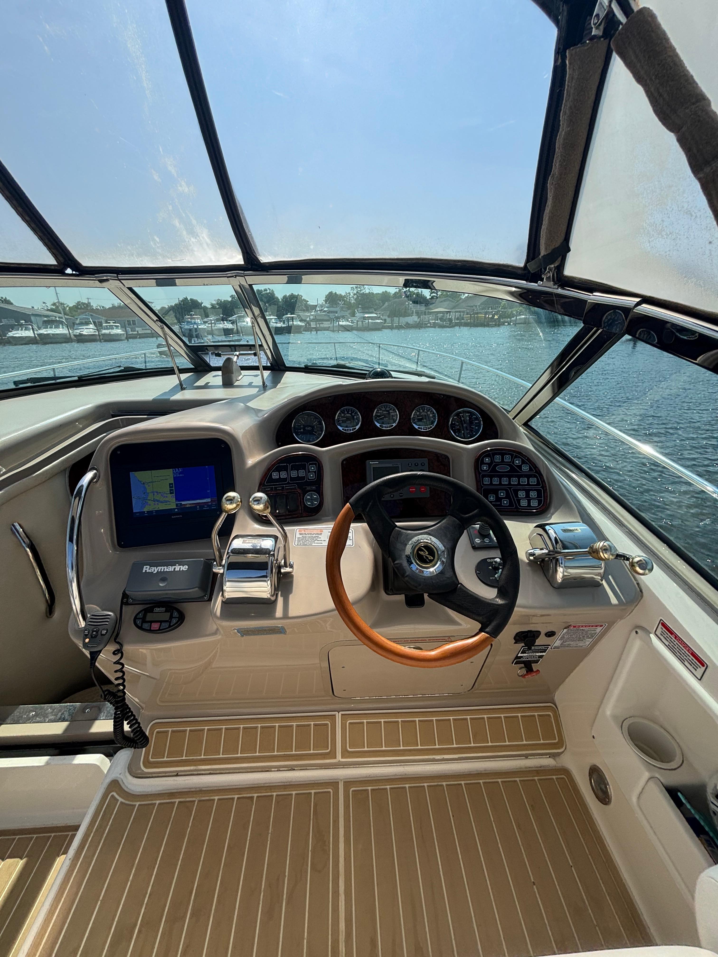 Cockpit of 2004 Sea Ray 320 Sundancer with steering wheel and navigation system.