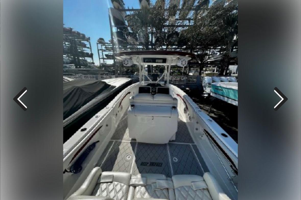 2015 Deep Impact 33 boat interior with seating and helm, docked outdoors.