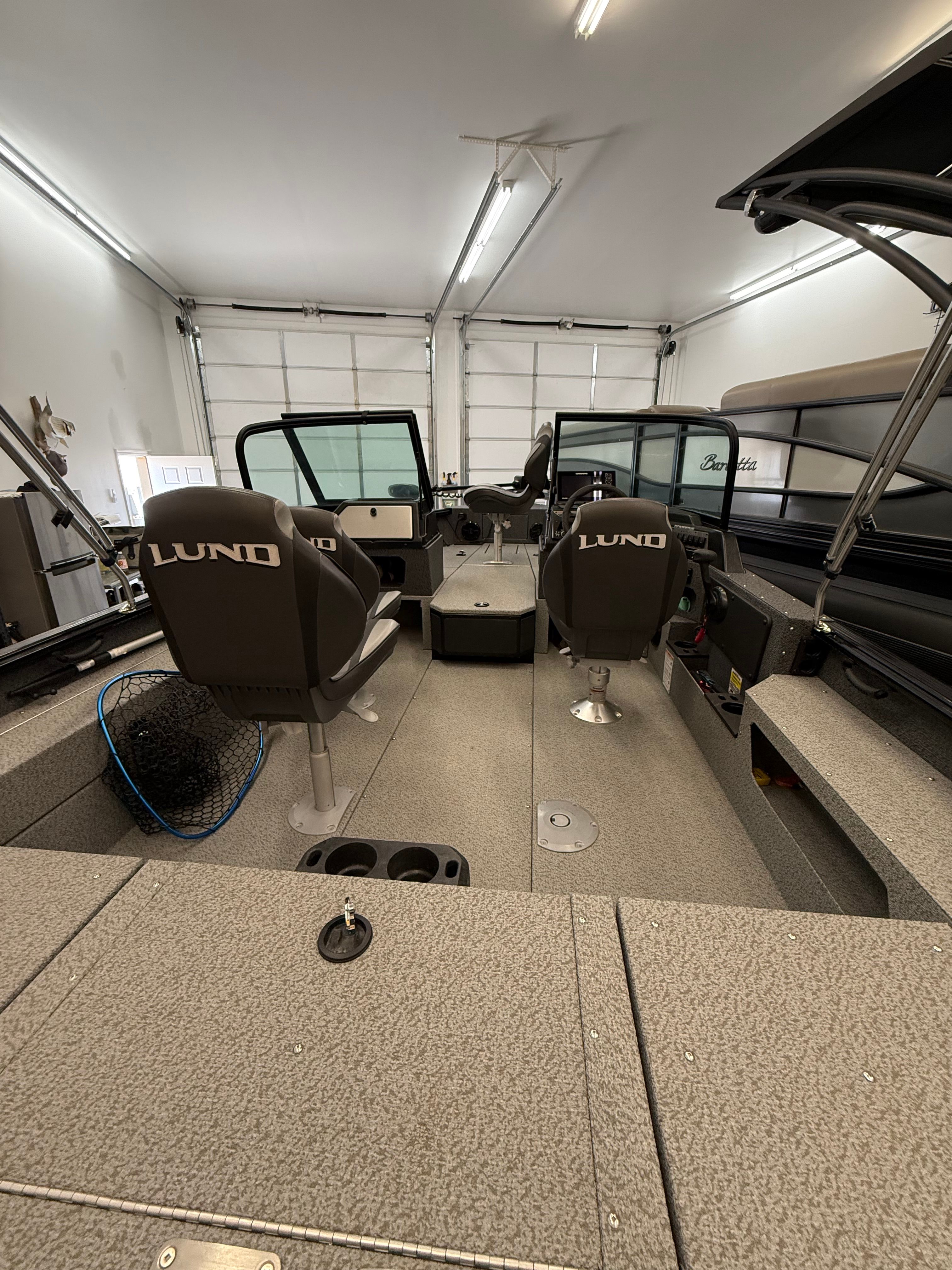 Interior view of a Lund 1875 Impact XS Sport boat in a garage.
