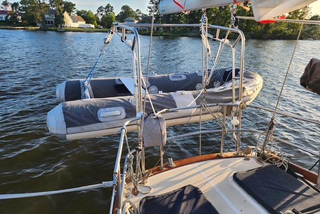 Sailboat with dinghy on davits, Bristol 45.5 Center Cockpit, 1984, on calm water.