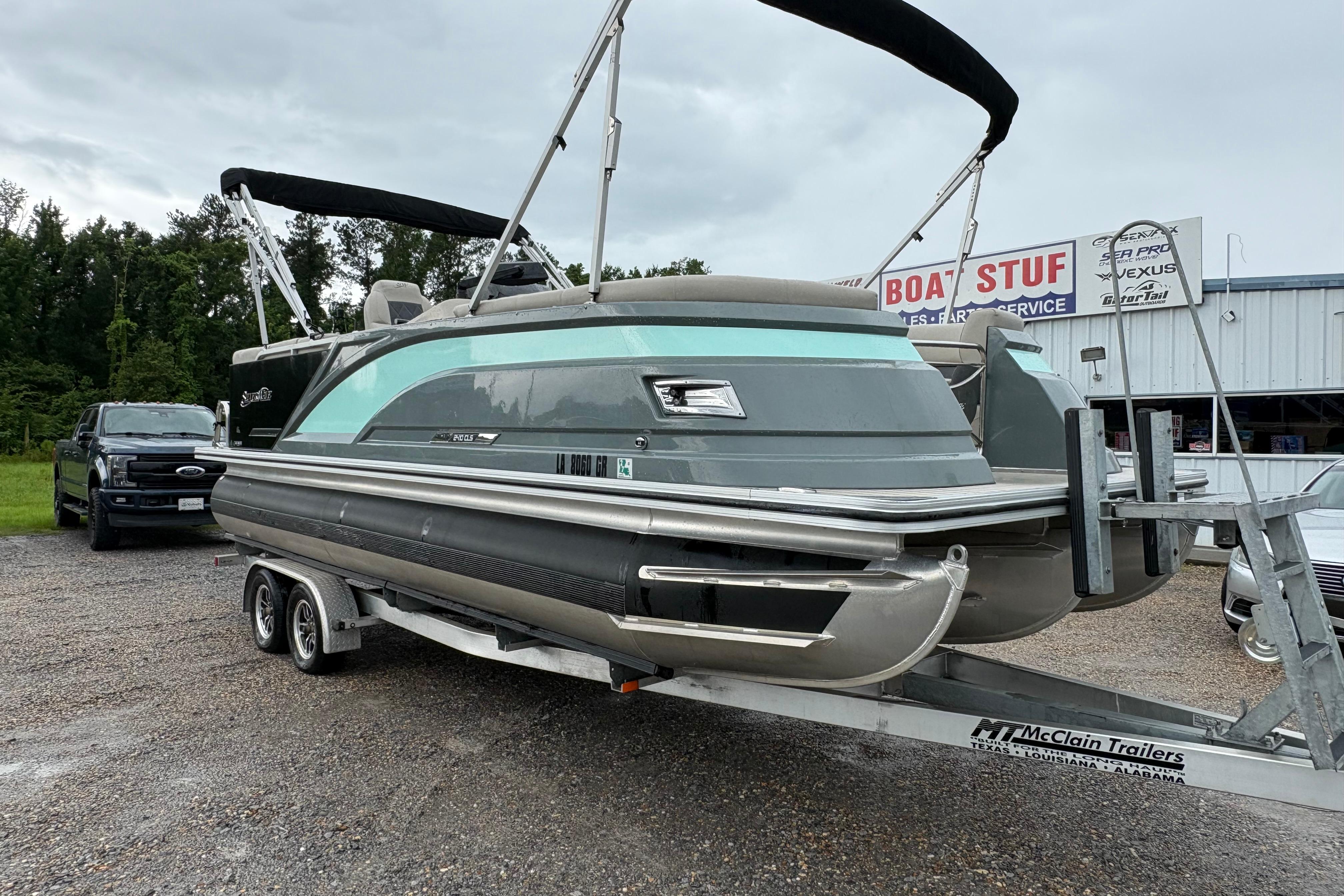 2023 SilverWave 2410 CLS pontoon boat on trailer at dealership, overcast day.