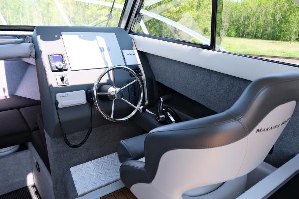 2023 Makaira Gen3 800 boat interior with steering wheel and captain's chair.