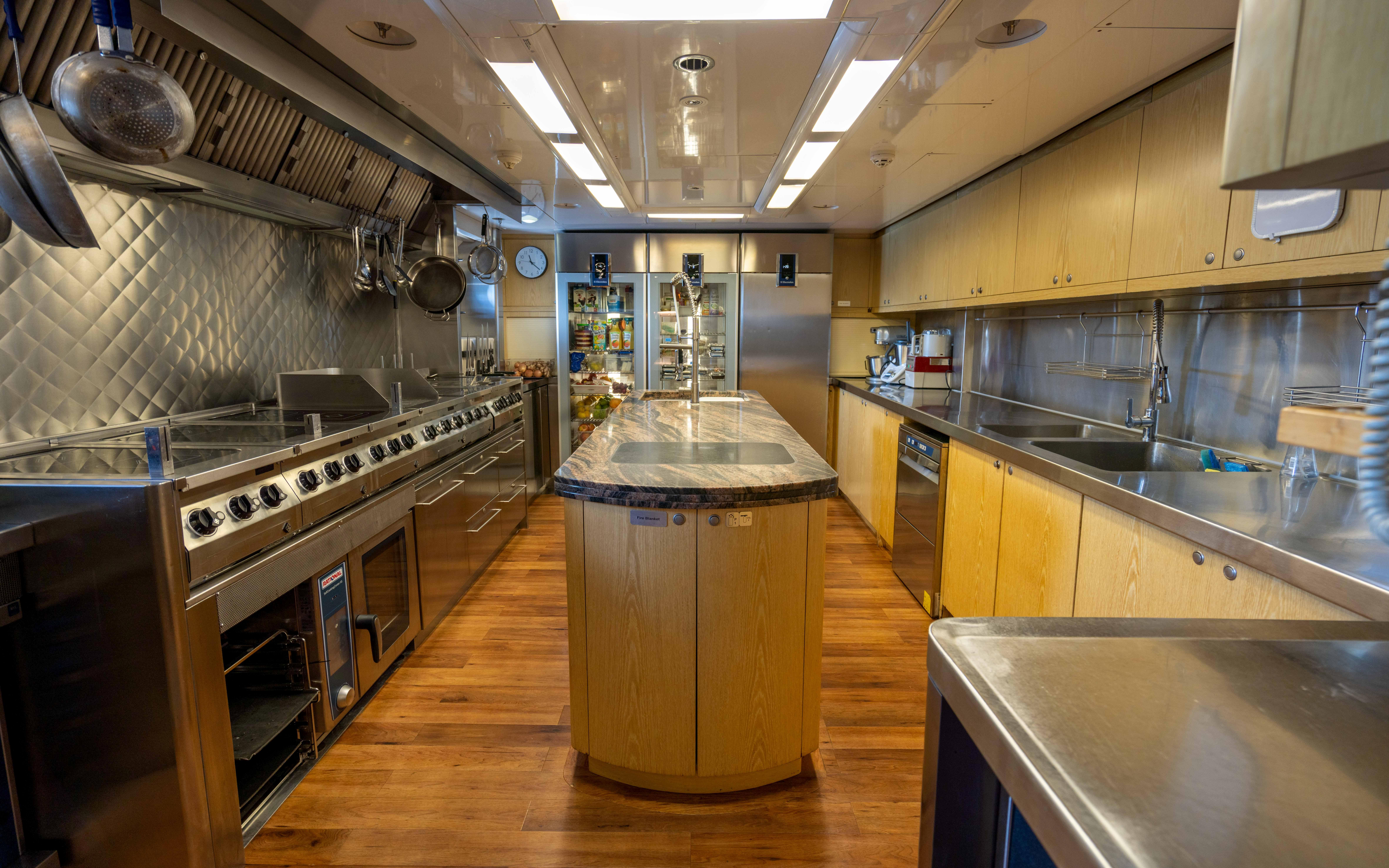 Luxurious kitchen in a 2004 Oceanfast Full Displacement yacht with modern appliances and wooden flooring.