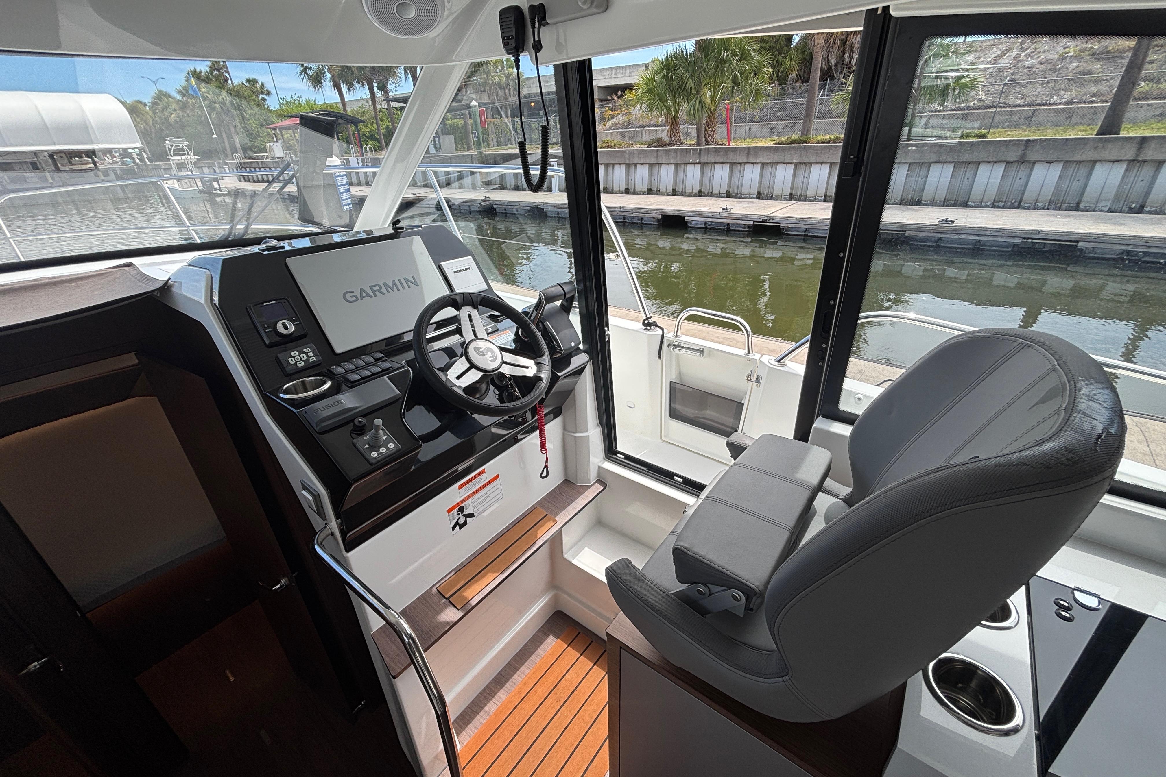 2024 Beneteau Antares 11 helm with Garmin navigation, luxurious seating, and waterfront view.