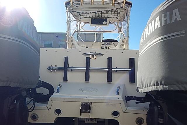 2003 World Cat 270 EC boat with Yamaha engines, rear view under clear sky.