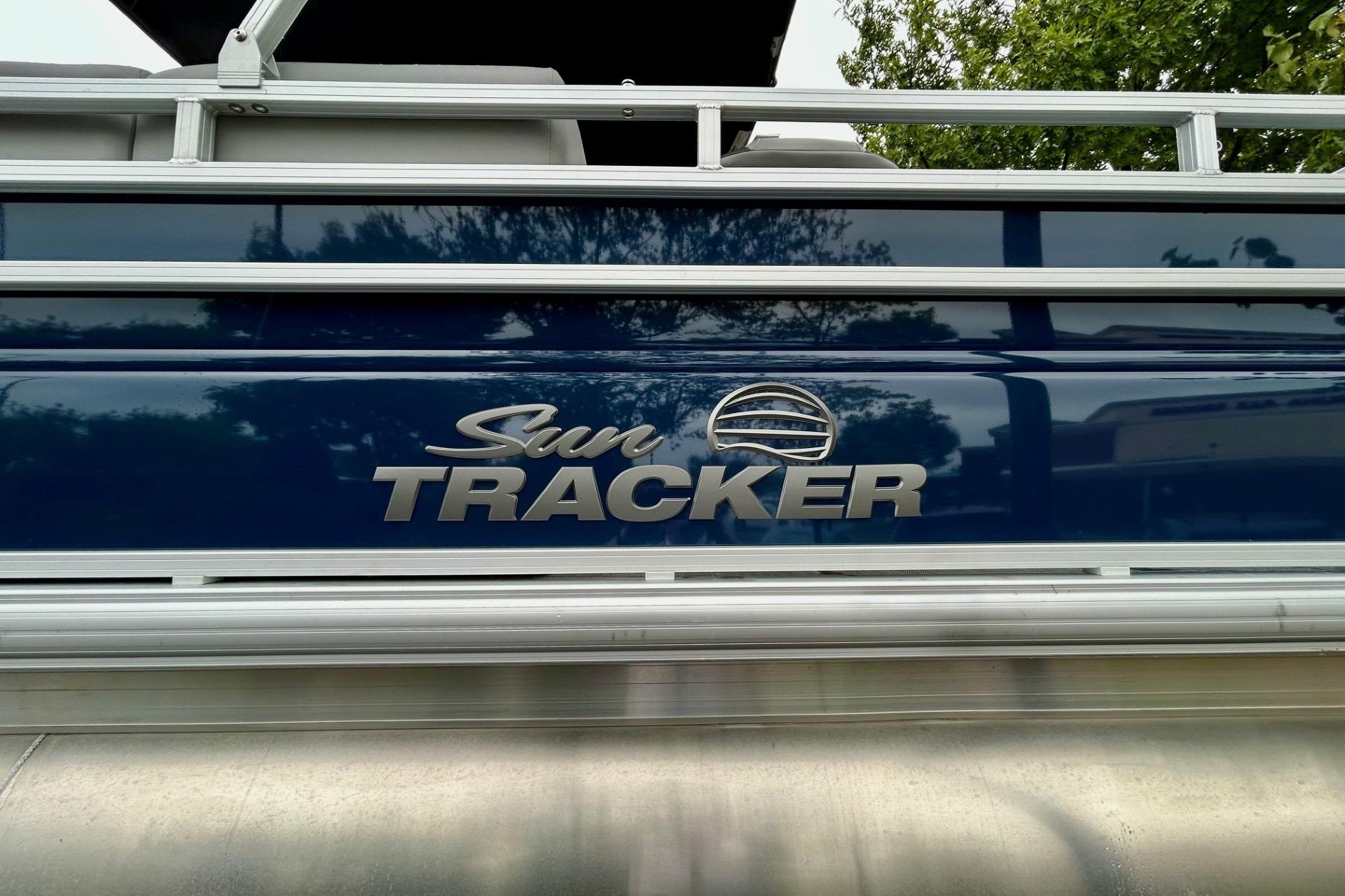2026 Sun Tracker SportFish 22 DLX pontoon boat with reflective blue exterior.