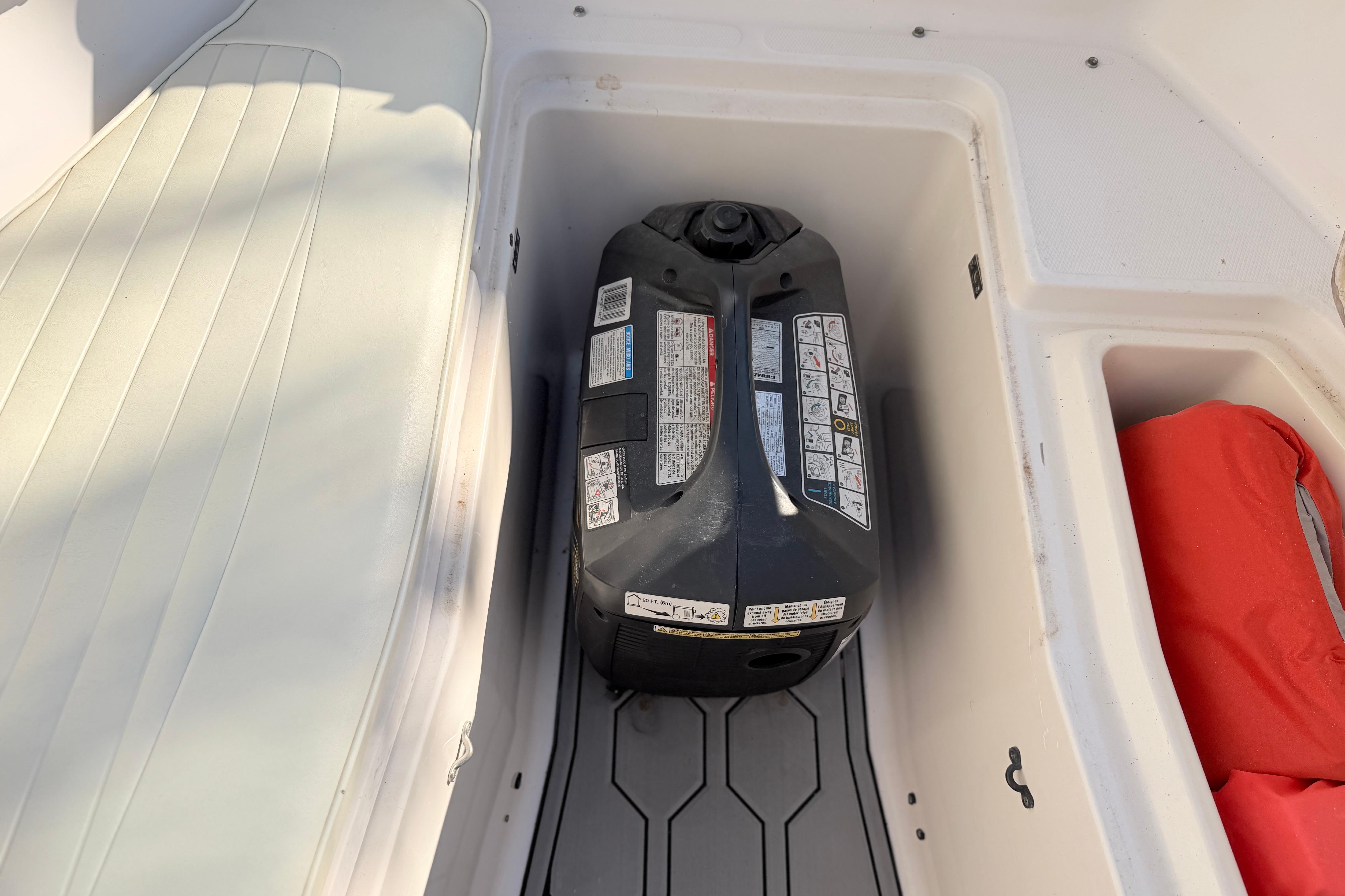 Storage compartment in a 2004 Grady White 273 boat with a fuel container.