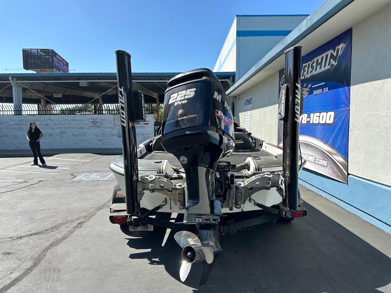 1999 Fisher 21 FX DC boat with Mercury 225 Pro motor in parking lot.