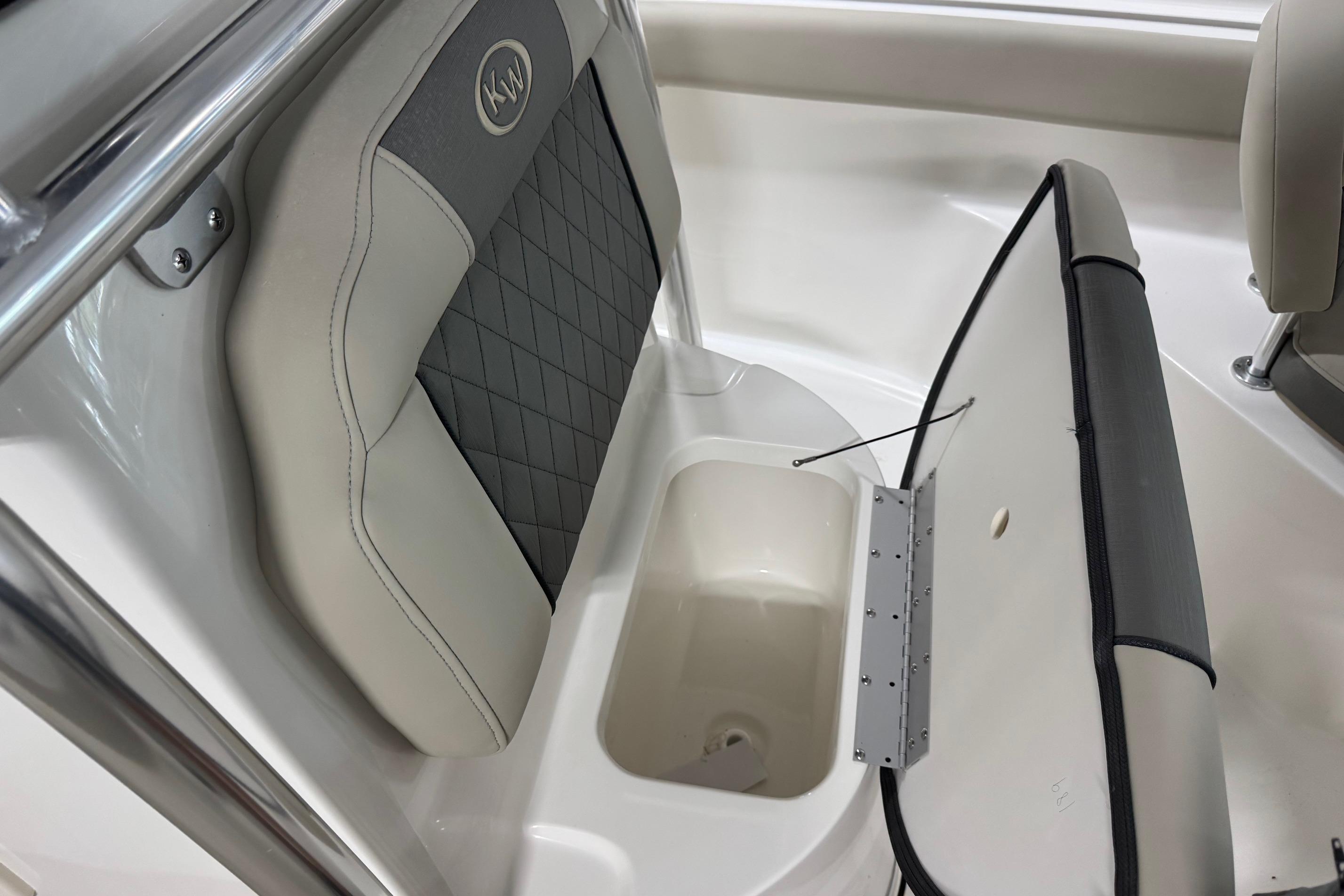 2026 Key West 203 FS boat seat with storage compartment open.