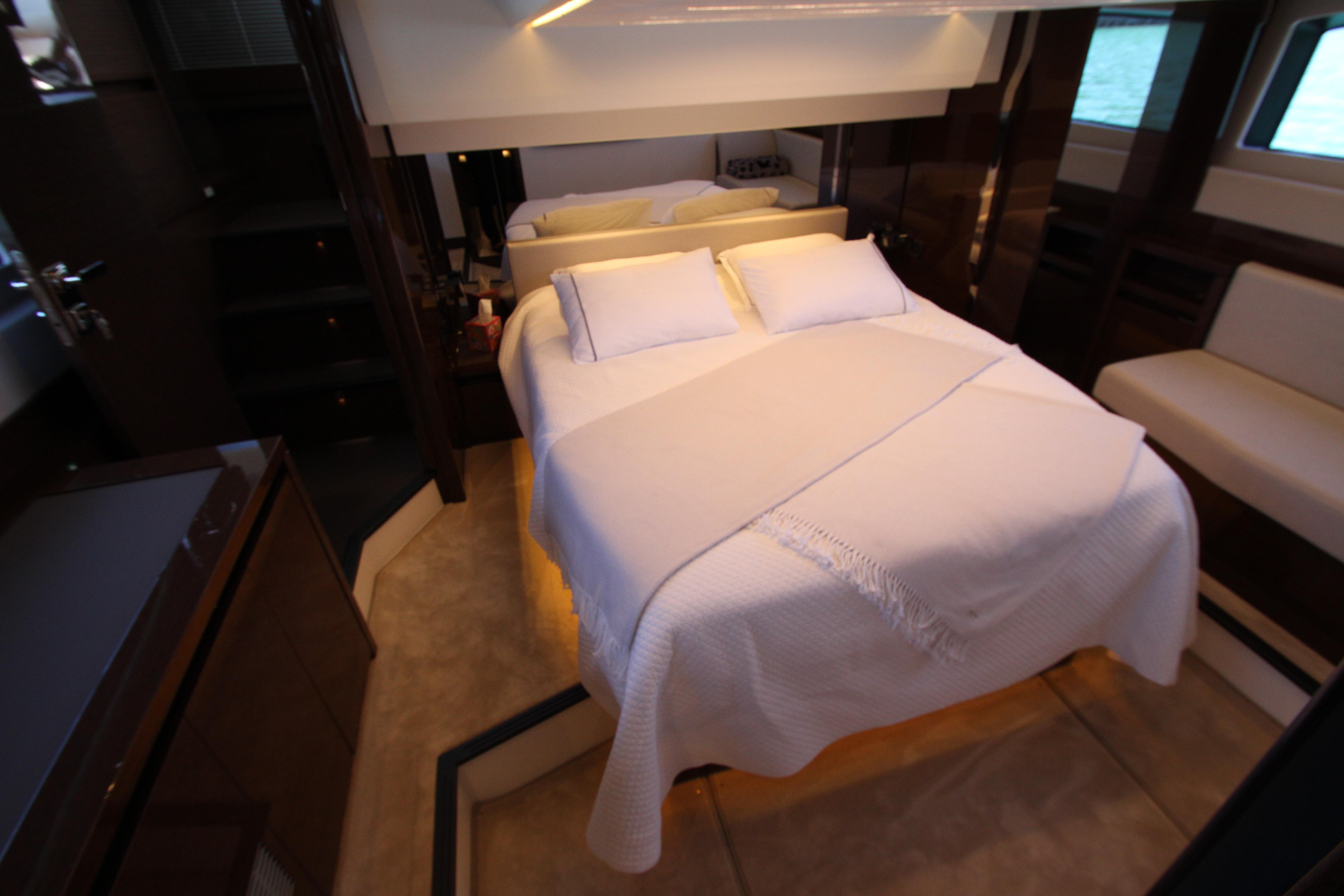 Luxurious bedroom interior of 2022 Prestige 520 yacht with elegant bedding and modern design.