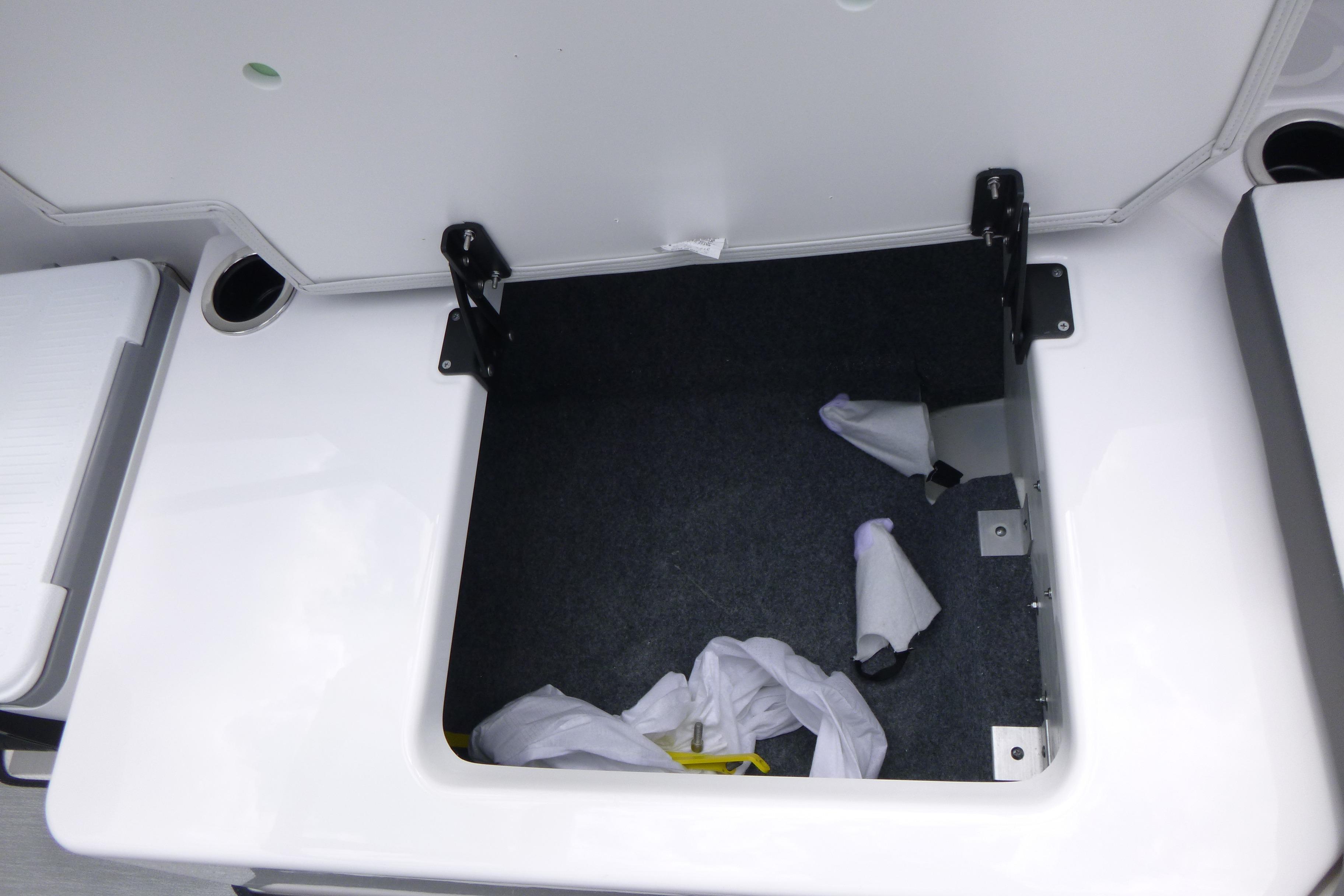 Open storage compartment in 2026 Yamaha AR250 boat, showing interior space and hinges.