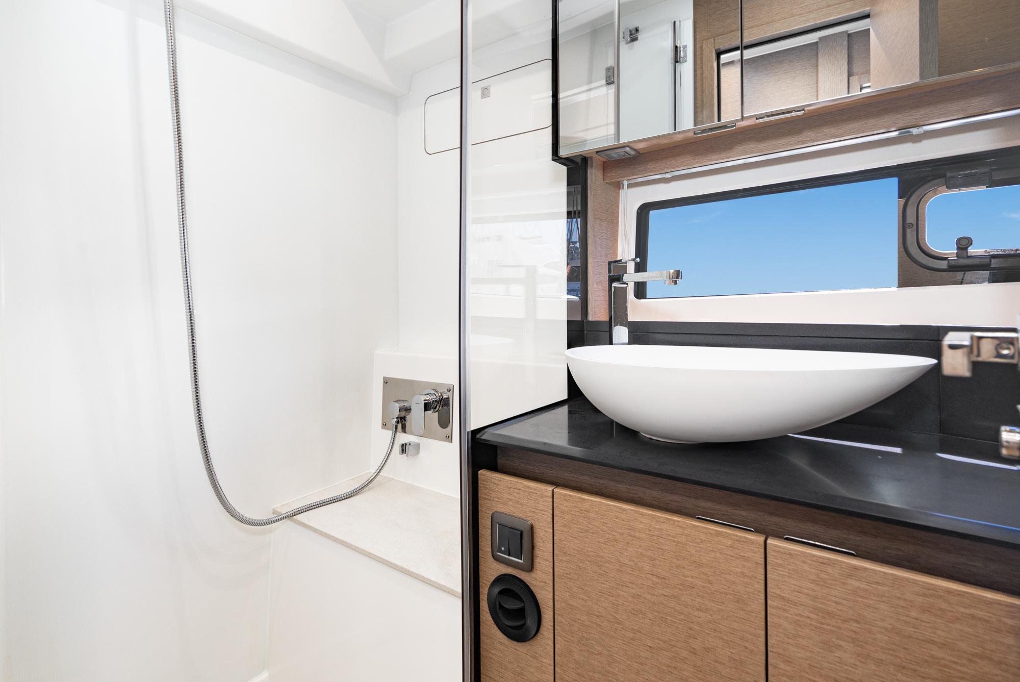 Modern bathroom in 2022 Prestige 460 yacht with sleek sink and shower.