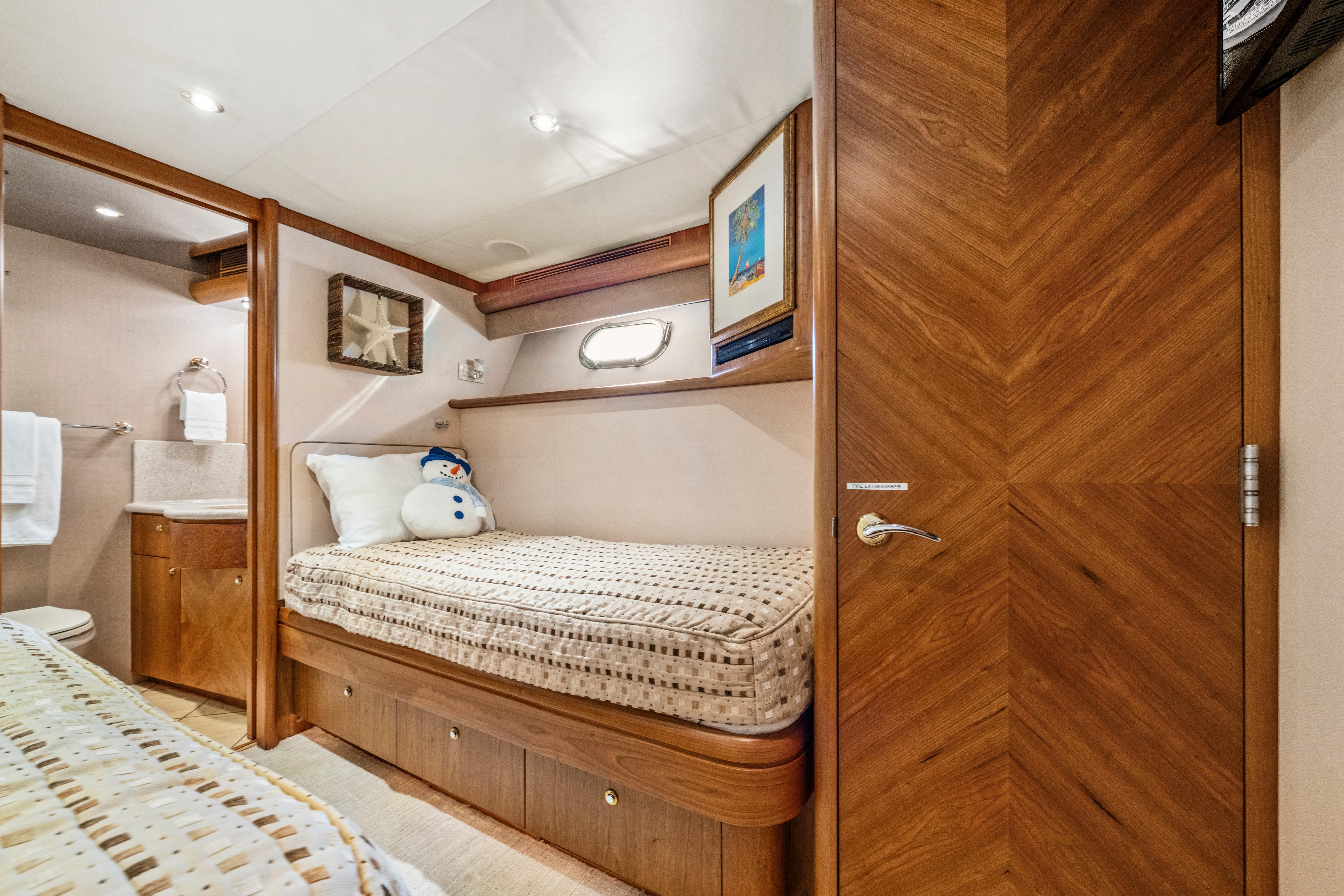 Luxurious 2006 Cheoy Lee 84 Bravo yacht cabin with cozy bed and elegant wood finishes.