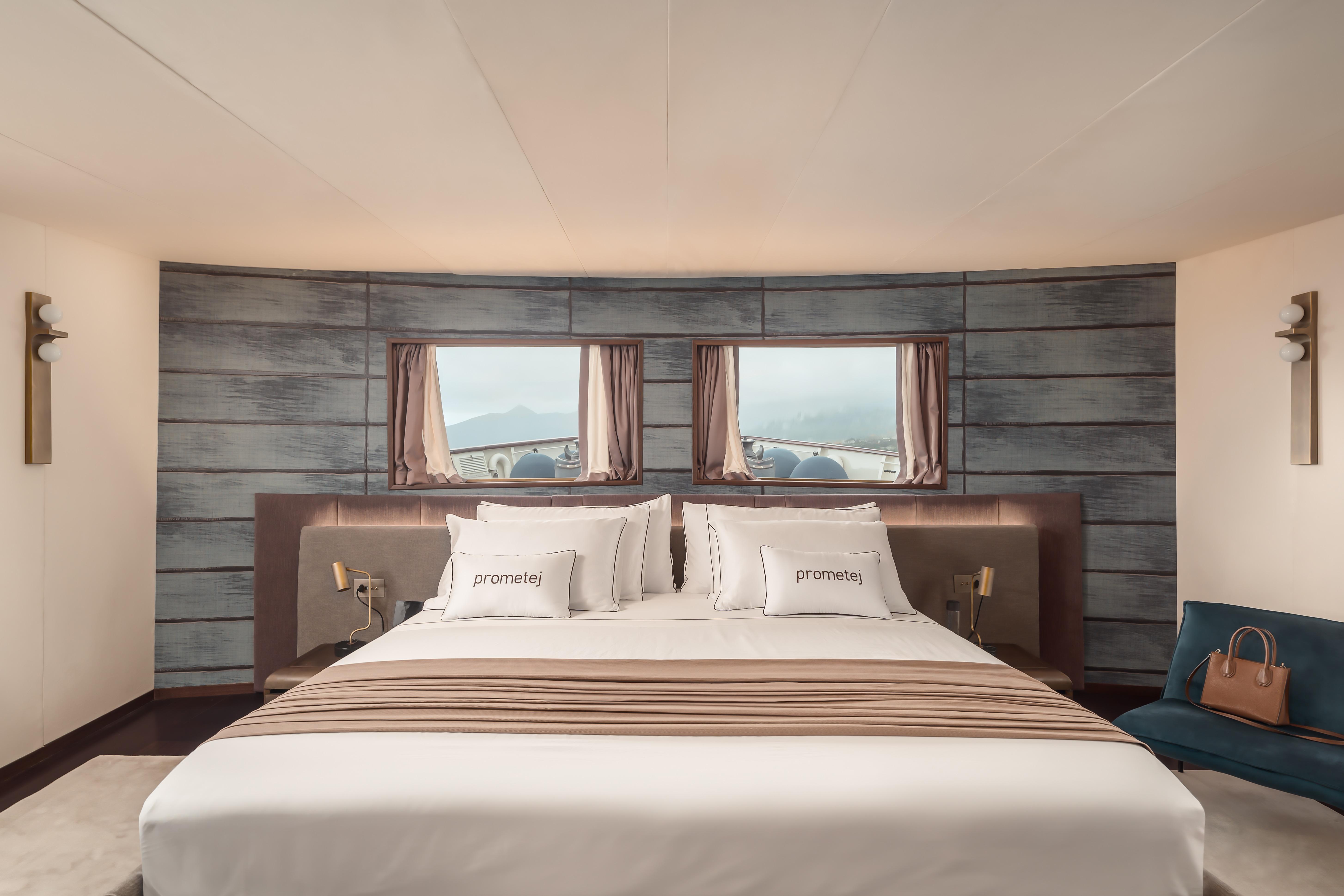Luxurious bedroom in a 1956 custom converted tugboat with elegant decor and scenic window views.