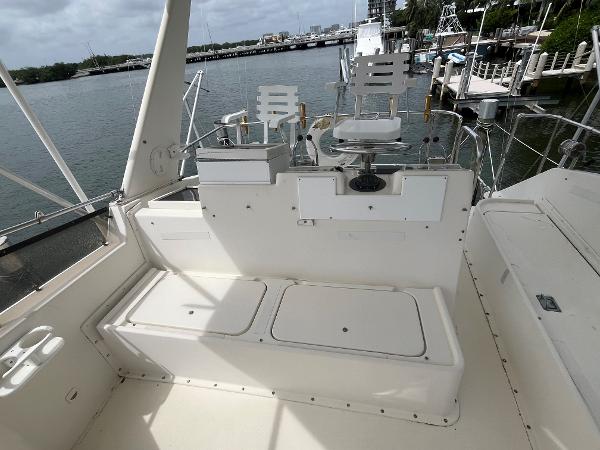 1985 Hatteras 45 Convertible boat deck with seating, overlooking marina.