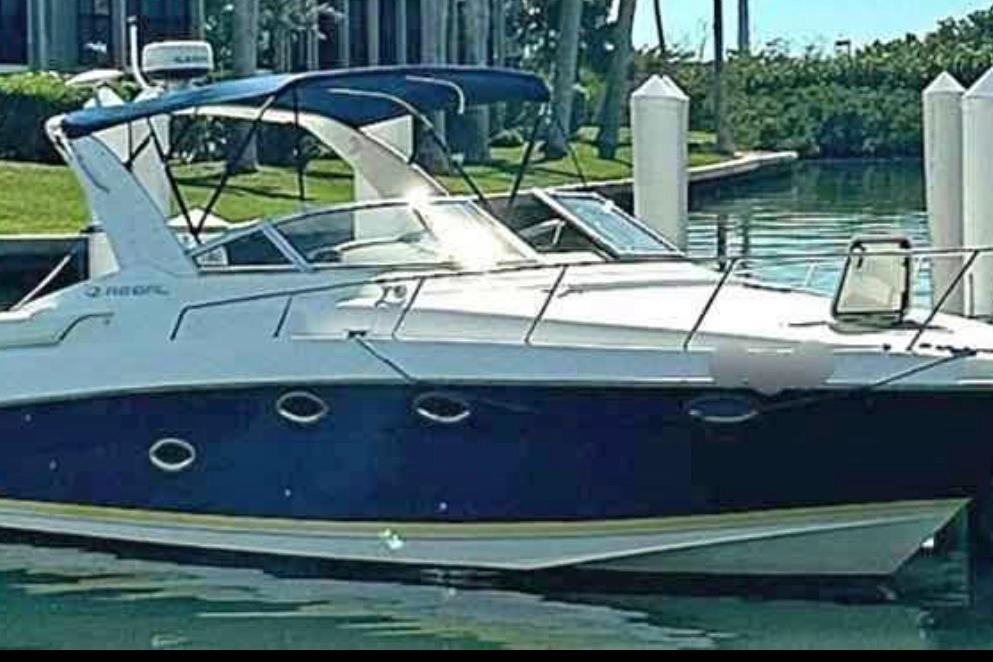 2003 Regal Commodore 3260 boat docked in a serene marina setting.