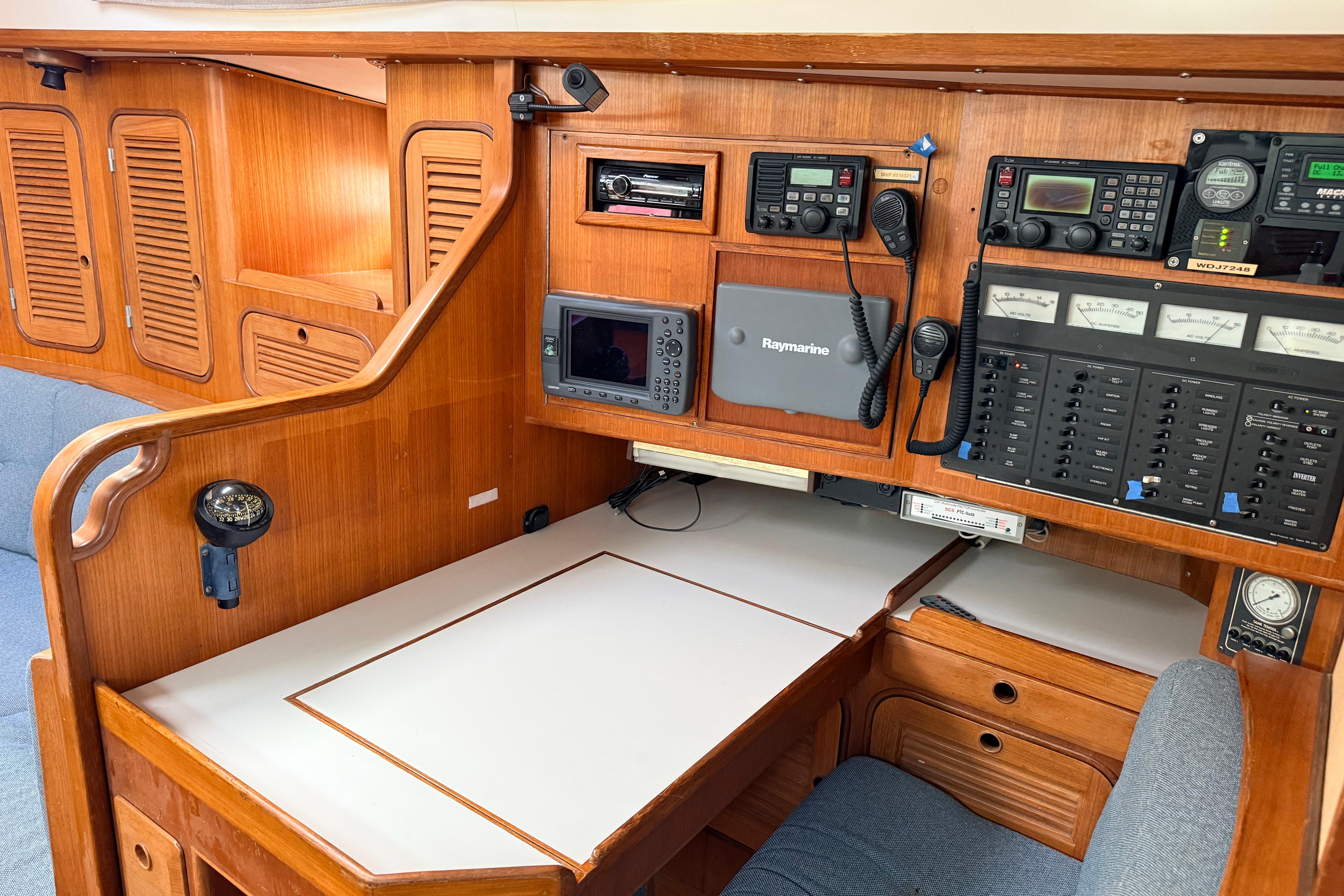 Navigation station of 1987 Norseman 400 yacht with control panels and wooden cabinetry.