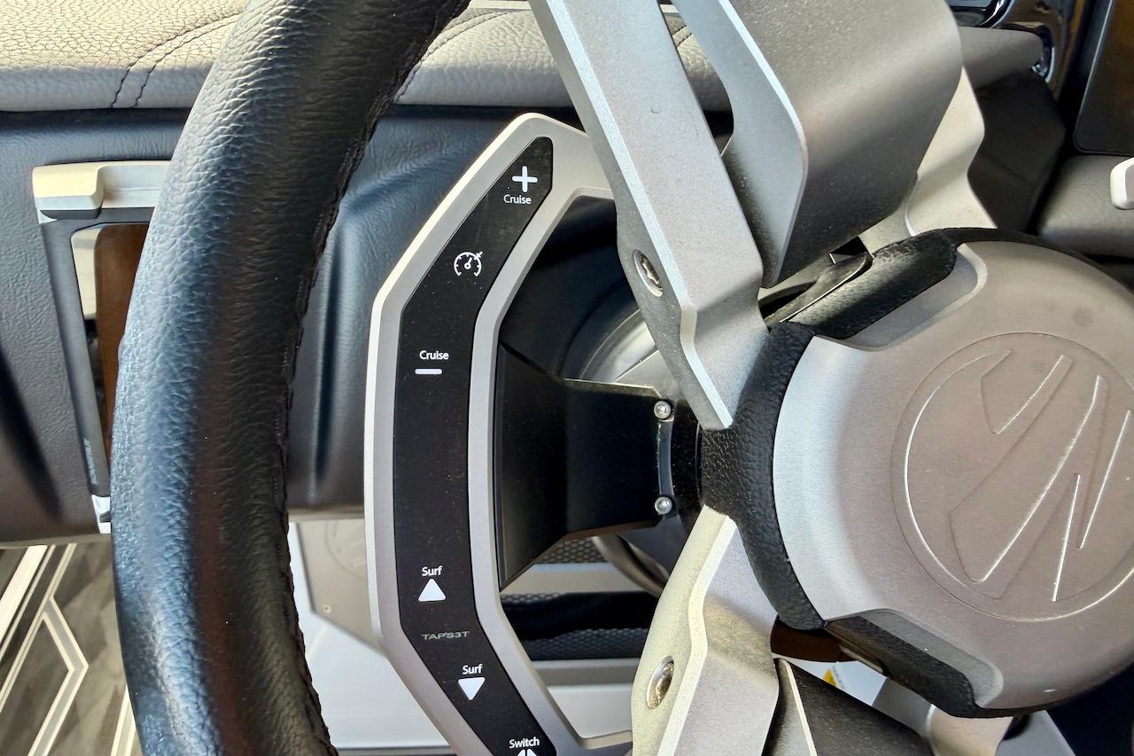 Steering wheel of 2025 Tigé Ultré 25ZX boat with cruise control and surf settings.