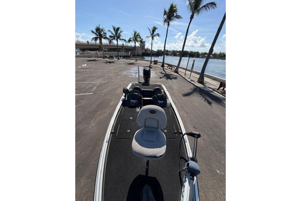 2005 Triton Tr-21X PD boat parked near waterfront with palm trees and clear sky.