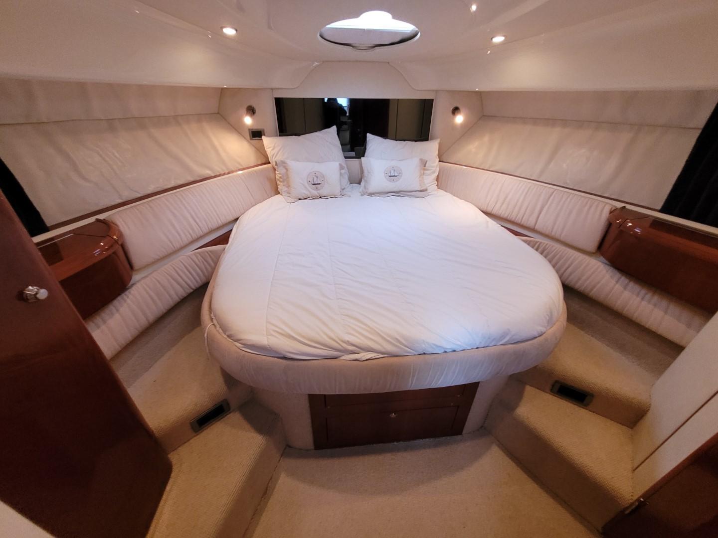 Luxurious cabin interior of 2004 Fairline Targa 43 yacht with plush bedding and ambient lighting.