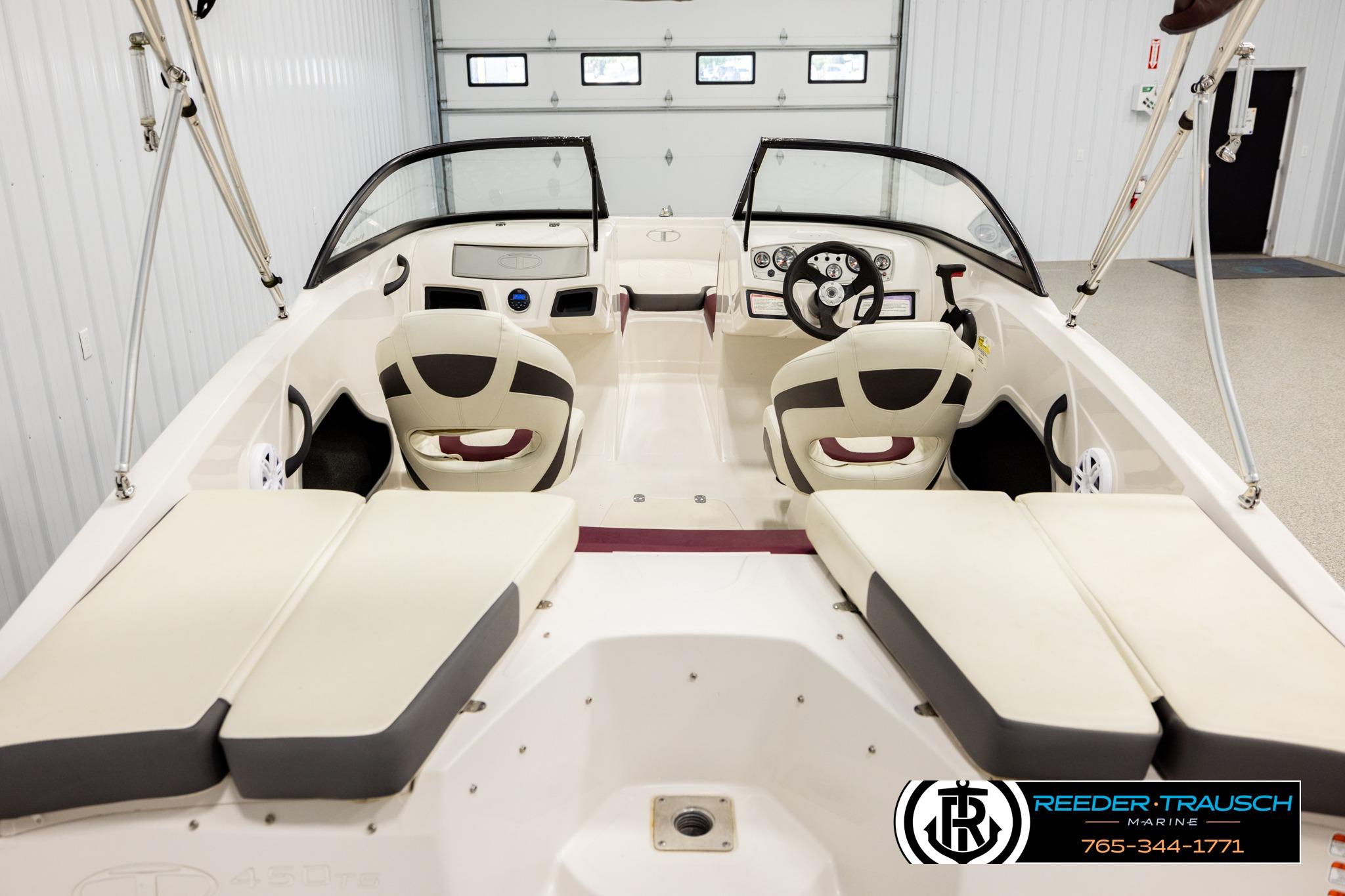Interior view of a 2016 Tahoe 450 TS boat, featuring seating and steering console.