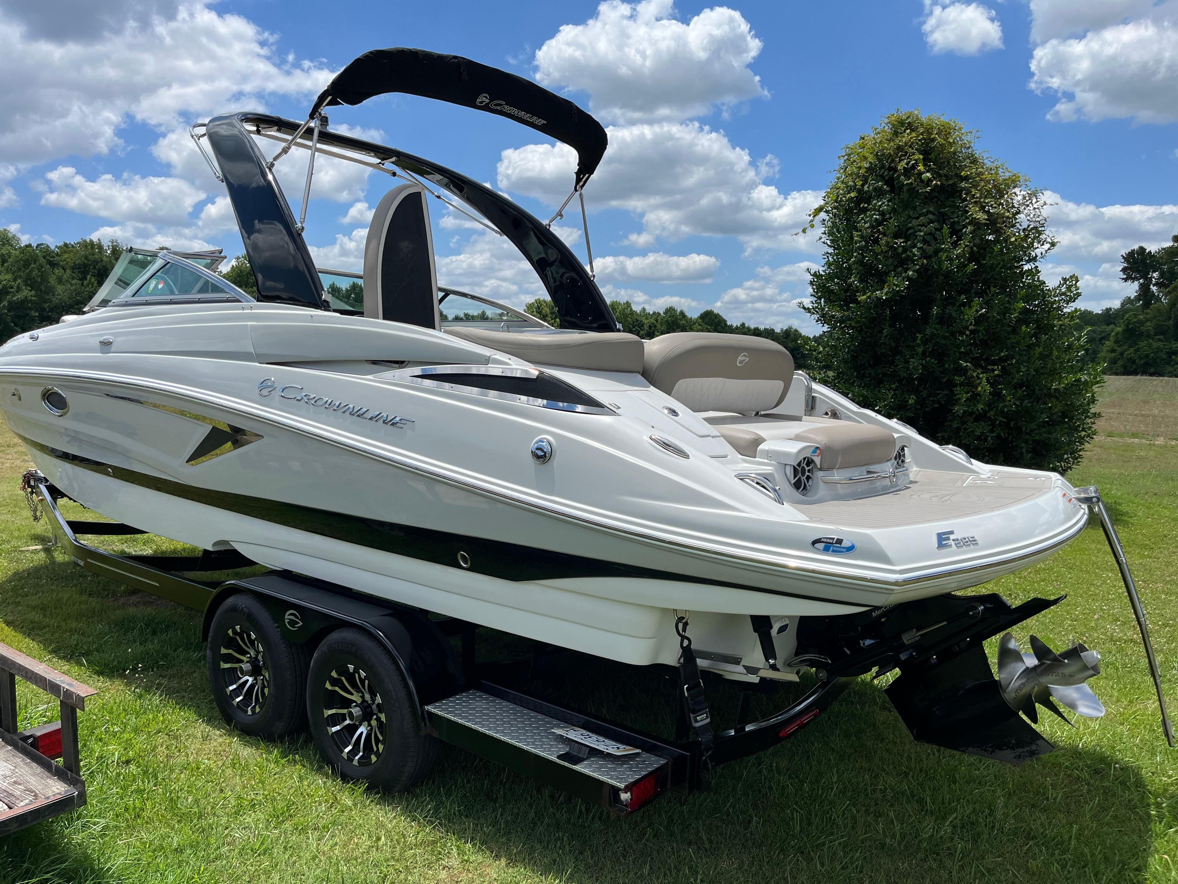 A 2019 Crownline E 285 boat on a trailer in a grassy area.