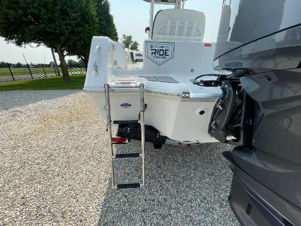 2025 Tidewater 232 CC Adventure boat with ladder on gravel surface.
