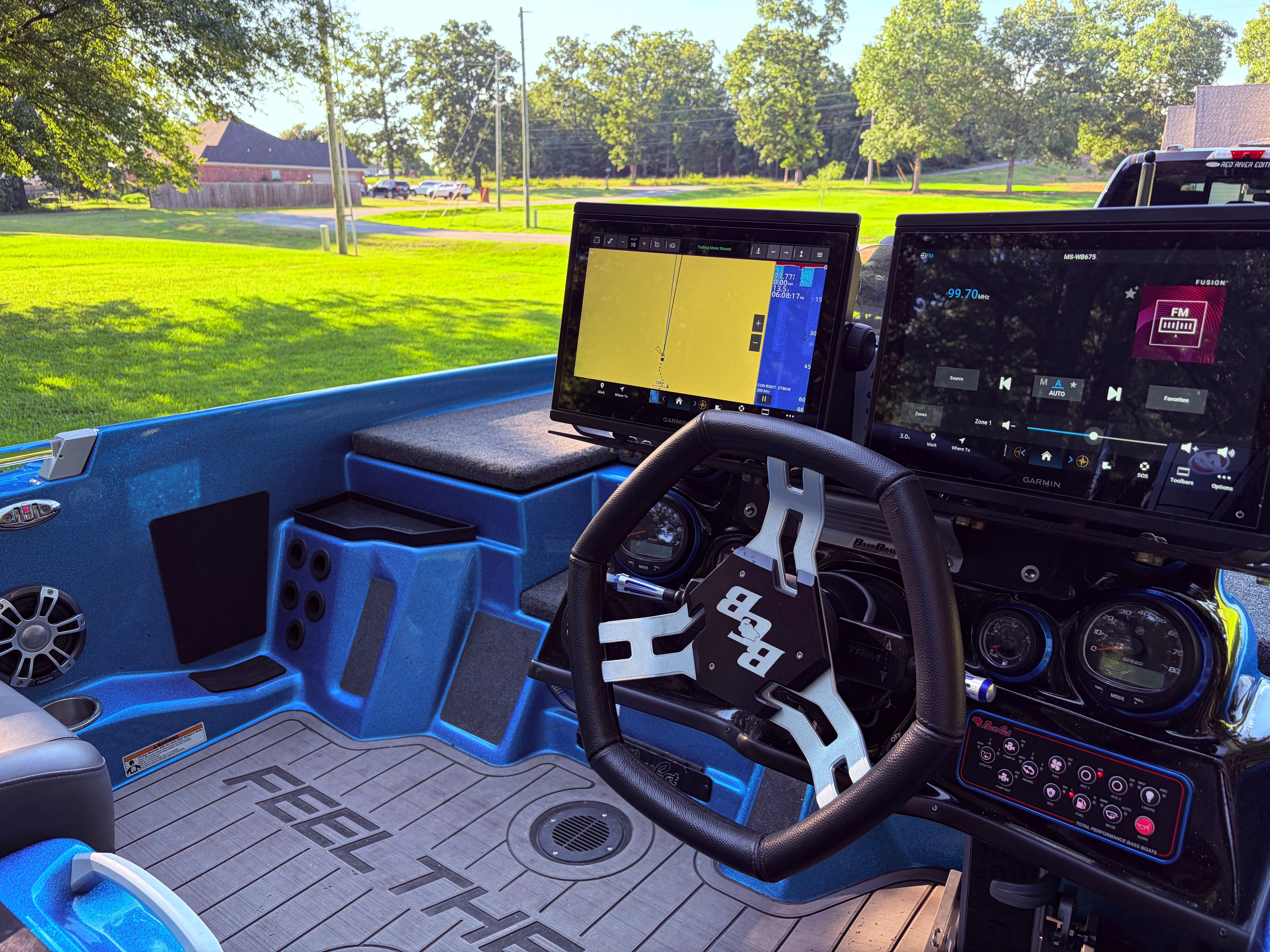 The cockpit of a 2023 Bass Cat Cougar FTD with modern navigation screens and a stylish steering wheel.