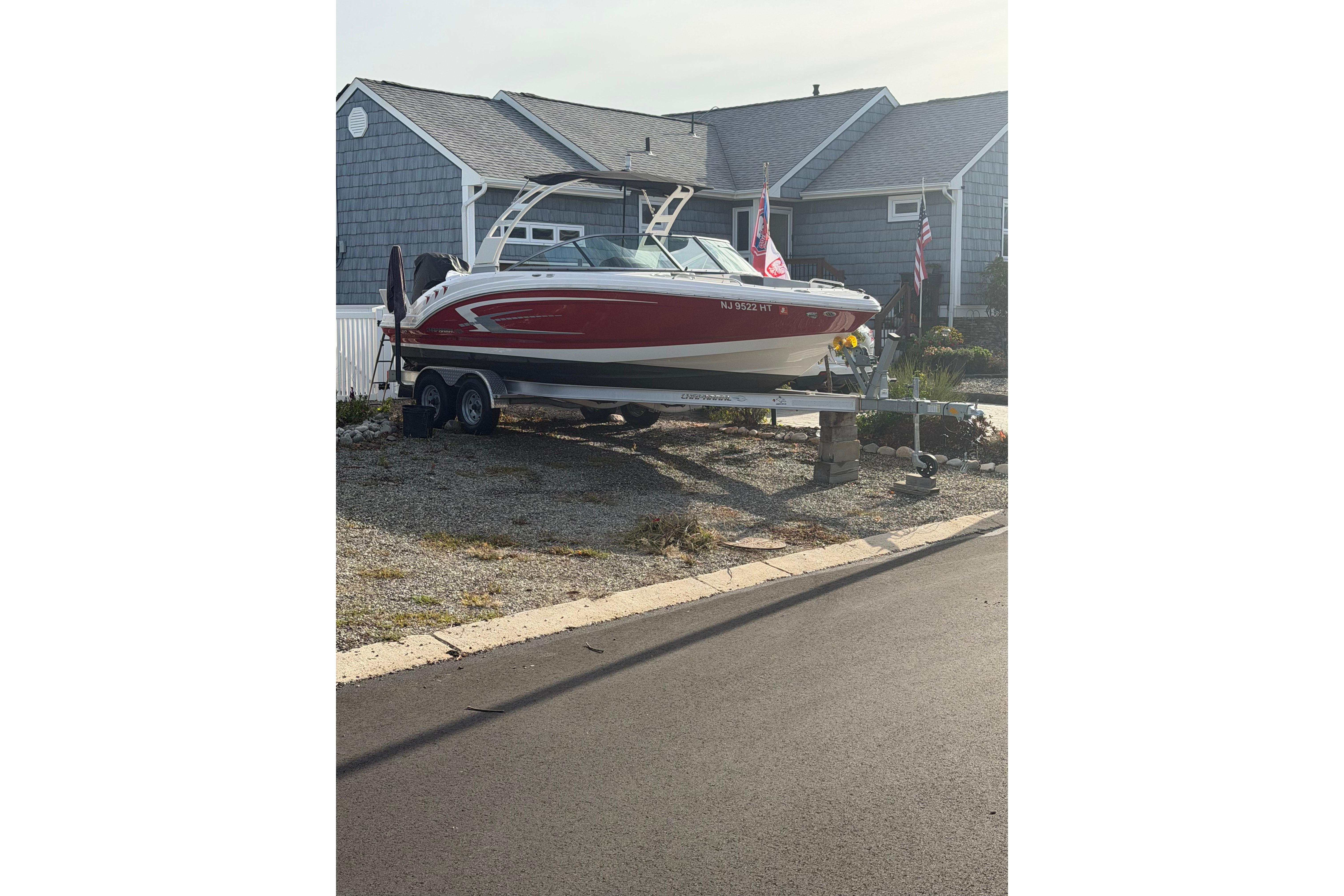 2024 Chaparral 23 SSi OB boat on trailer in residential driveway.