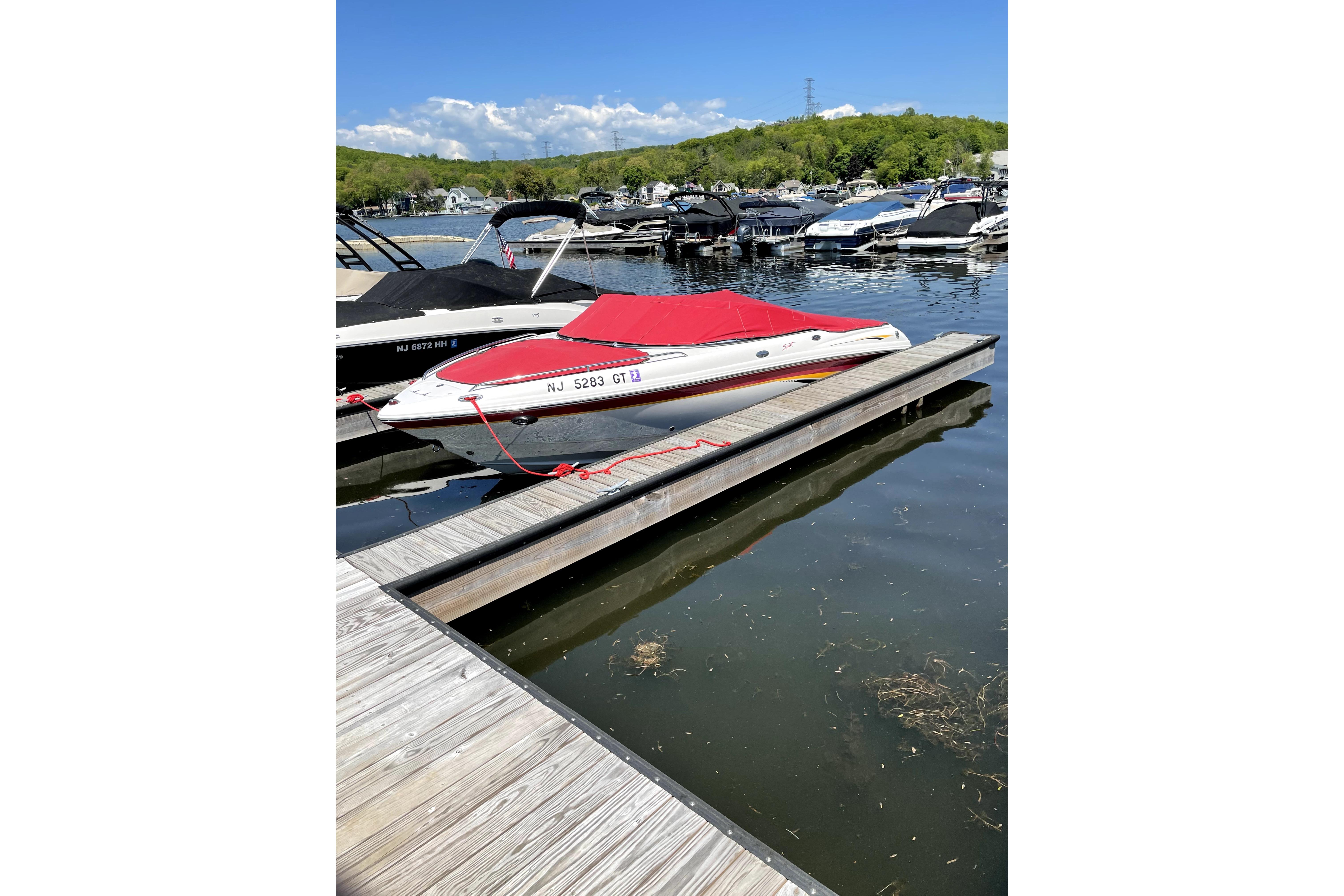 2003 Chaparral 200 SSi boat docked with red cover in a marina setting.