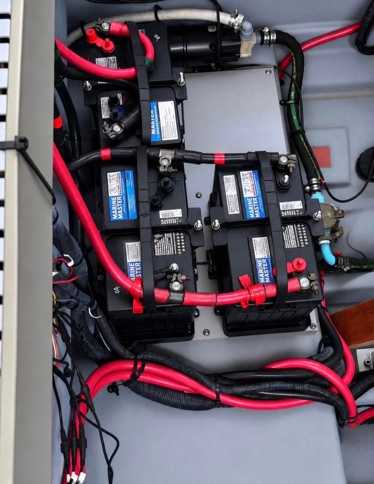 Batteries and wiring in a boat's engine compartment, neatly arranged and easily accessible.