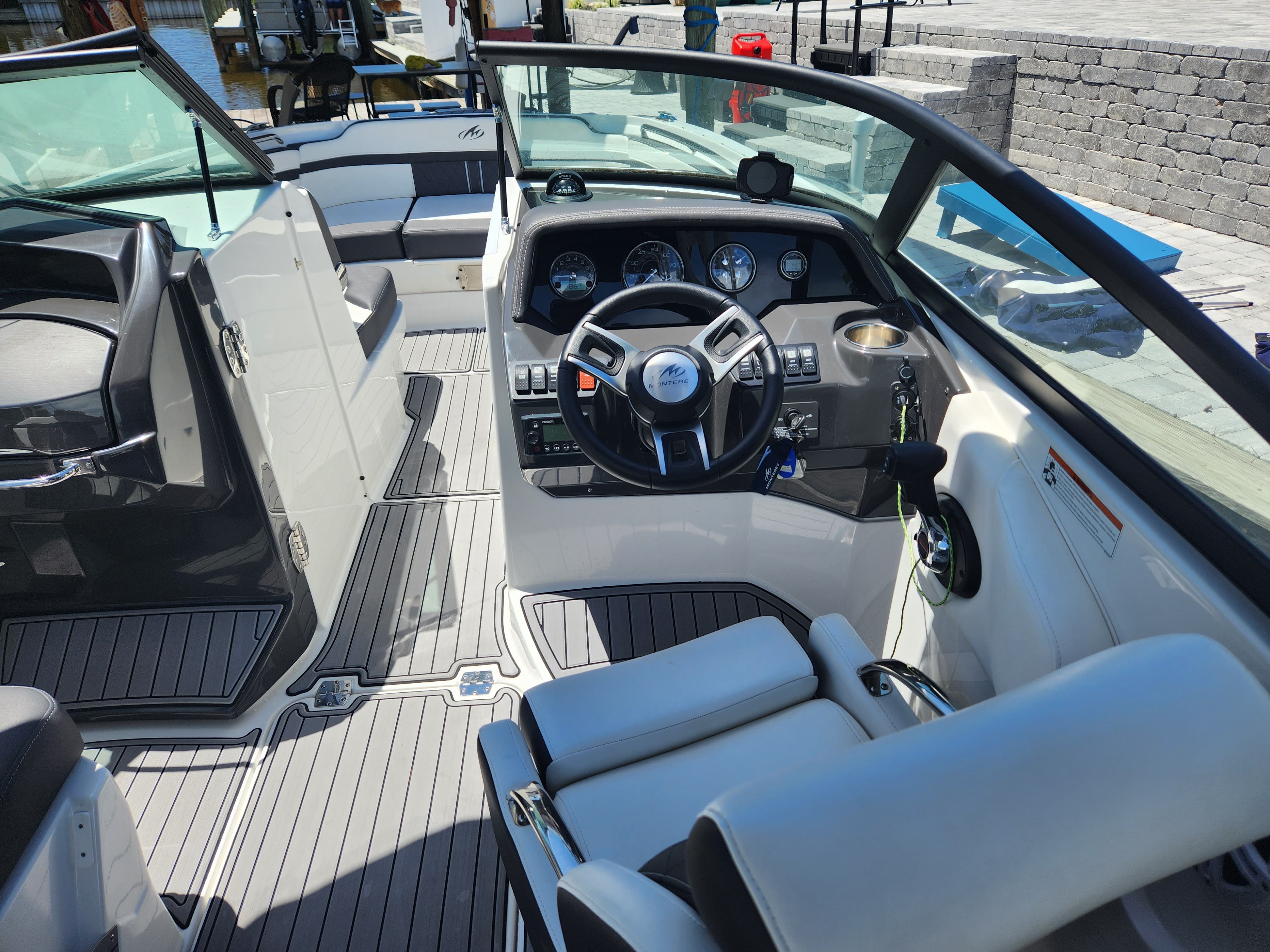 The image shows the cockpit of a 2021 Monterey M6 boat with modern instruments and white seating.