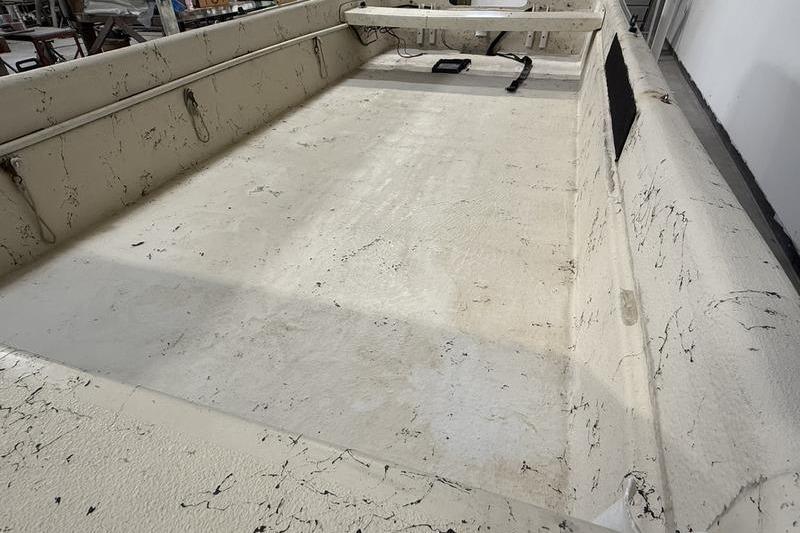 1998 Carolina Skiff 1965 V boat interior with textured flooring and side rails.