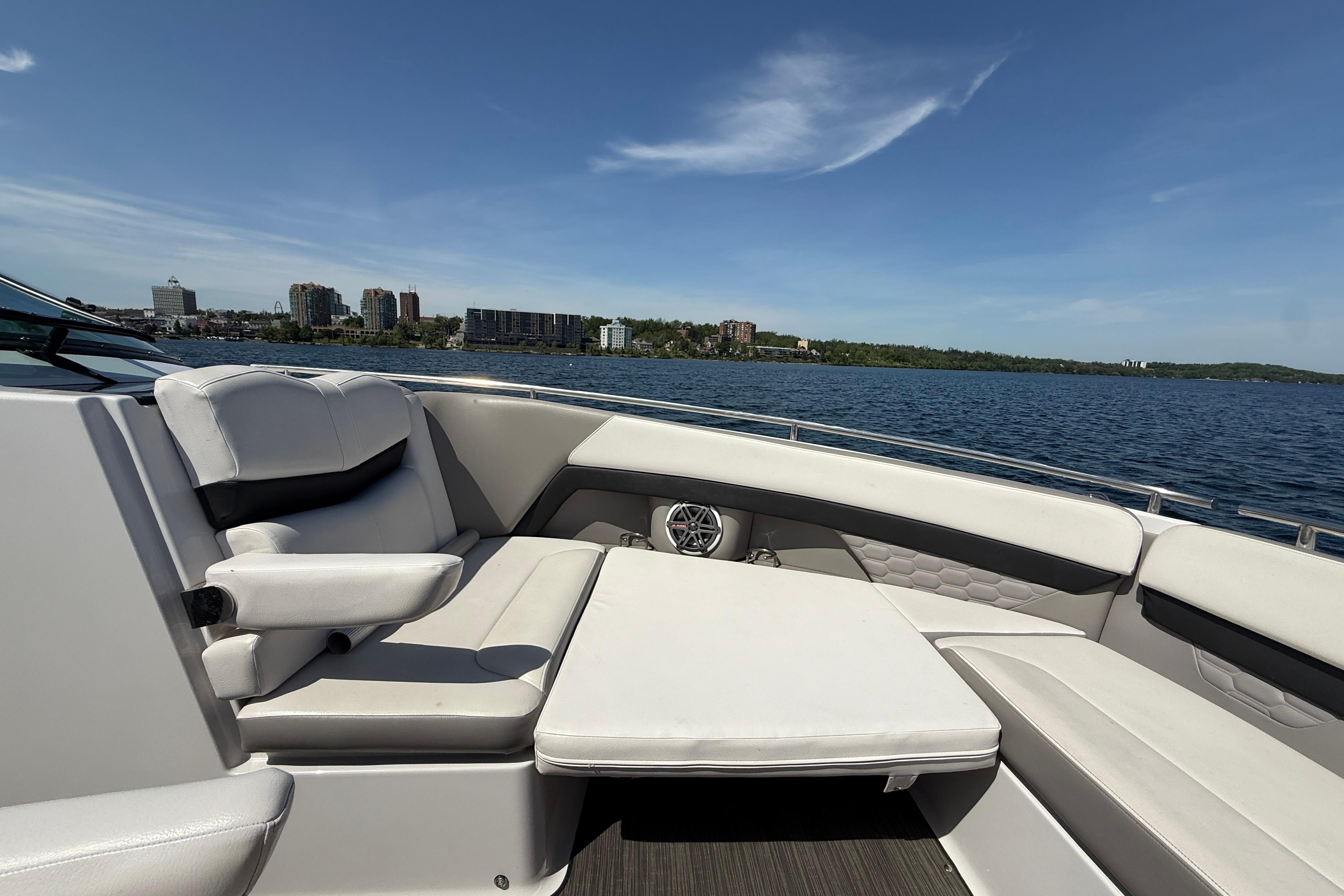 2018 Four Winns H350 boat interior with luxurious seating, cruising on a serene lake.