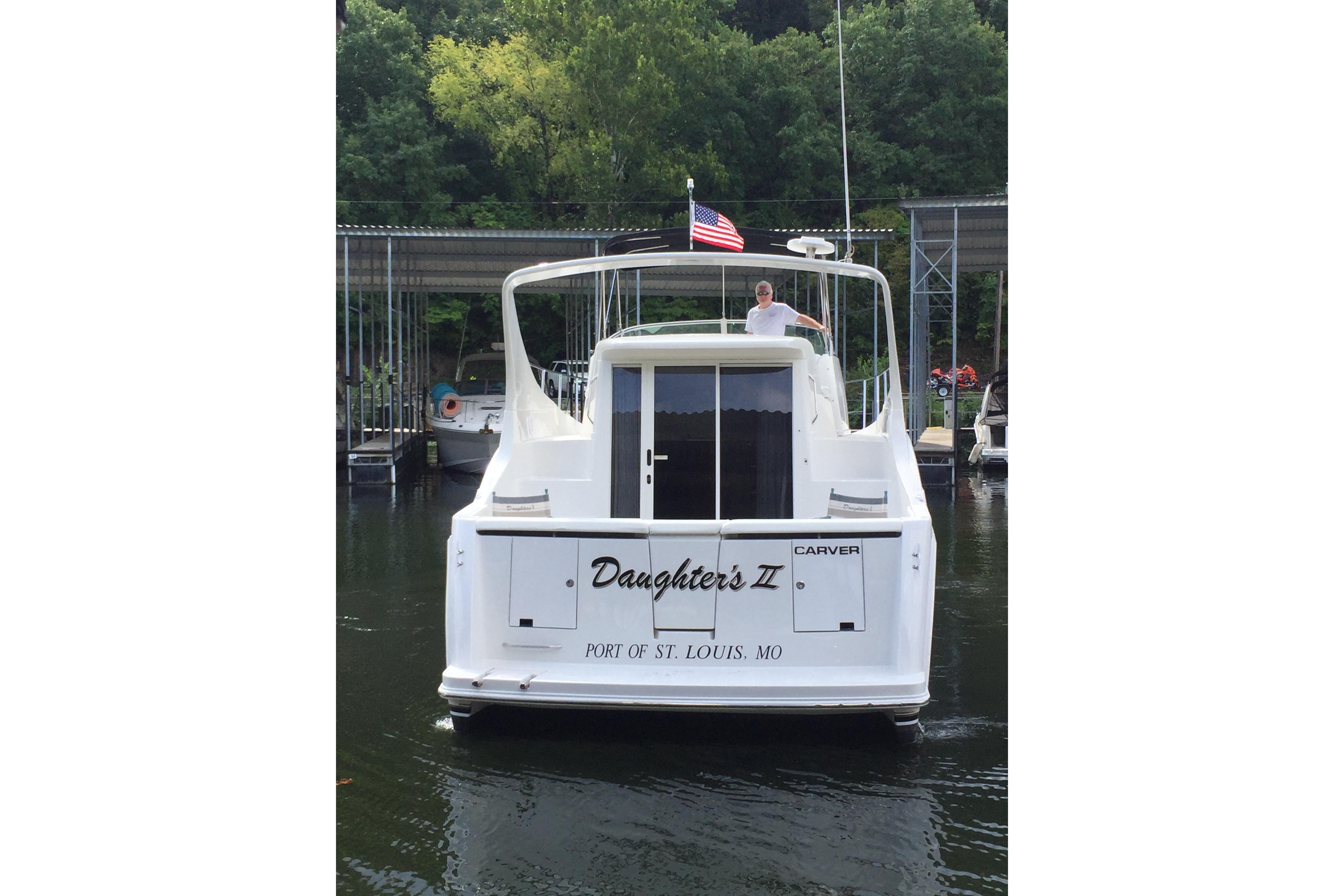 2000 Carver 350 Mariner boat docked, rear view, with American flag, St. Louis port.
