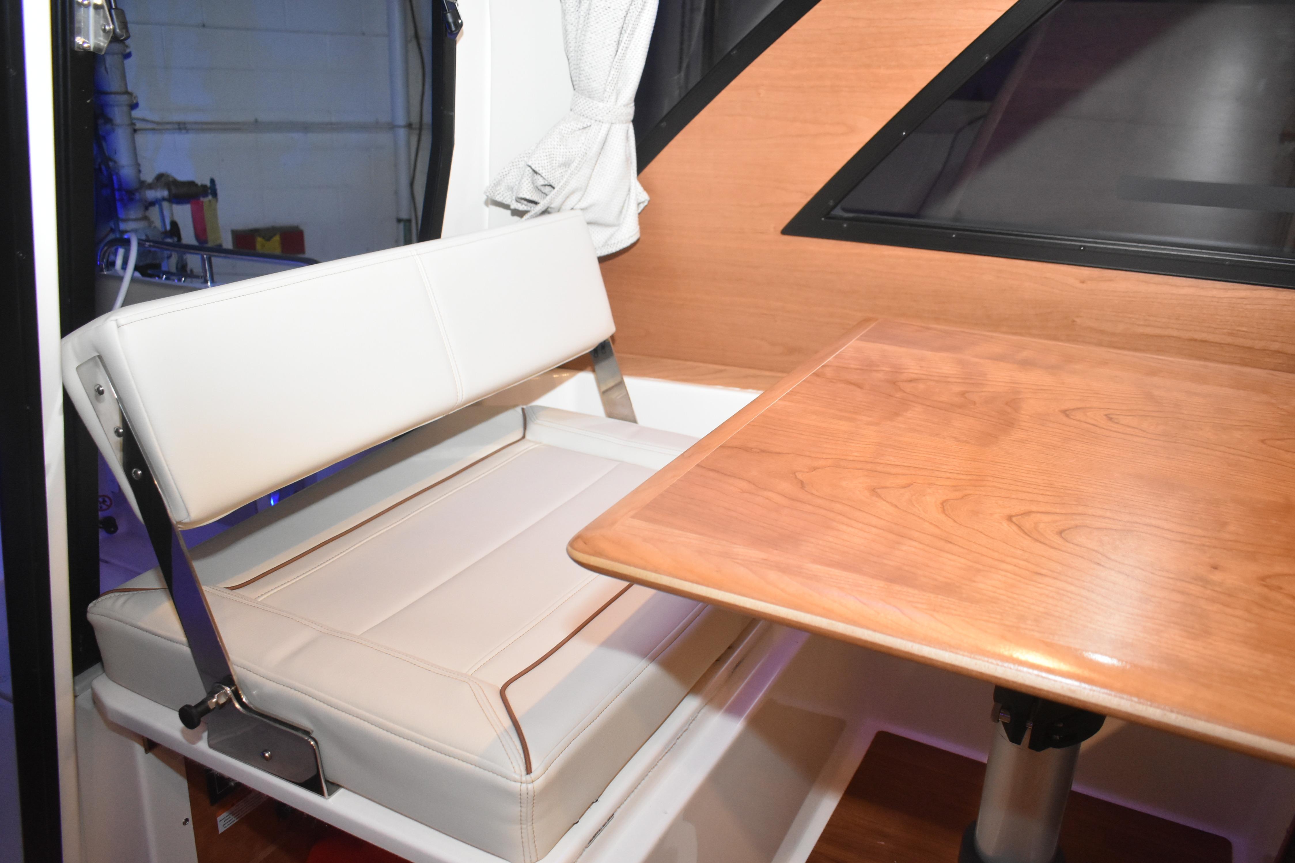 2026 Cutwater C-248 Coupe interior with white seating and wooden table.