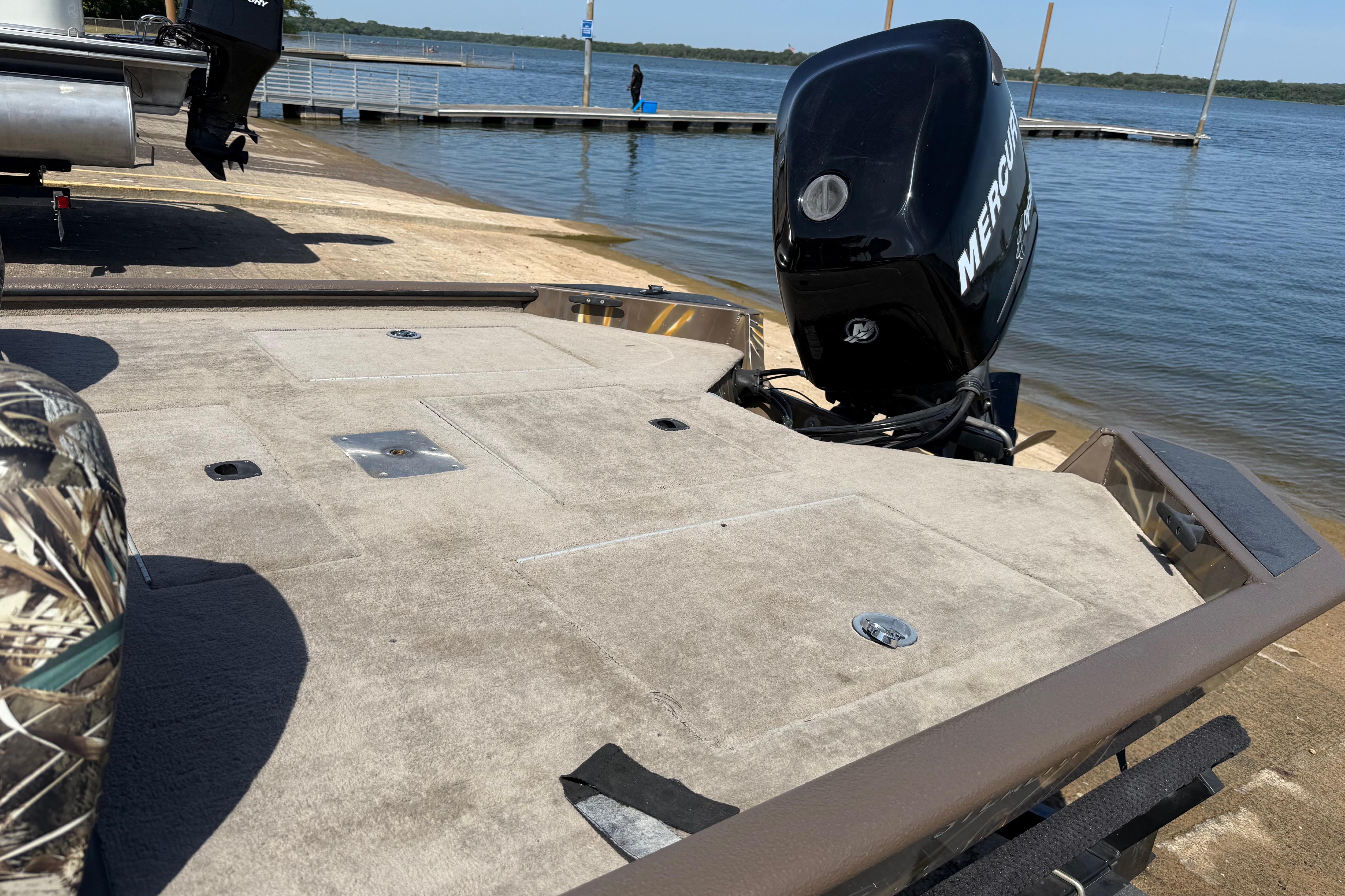 2010 SeaArk Stealth 190 boat with Mercury engine at a lakeside dock.