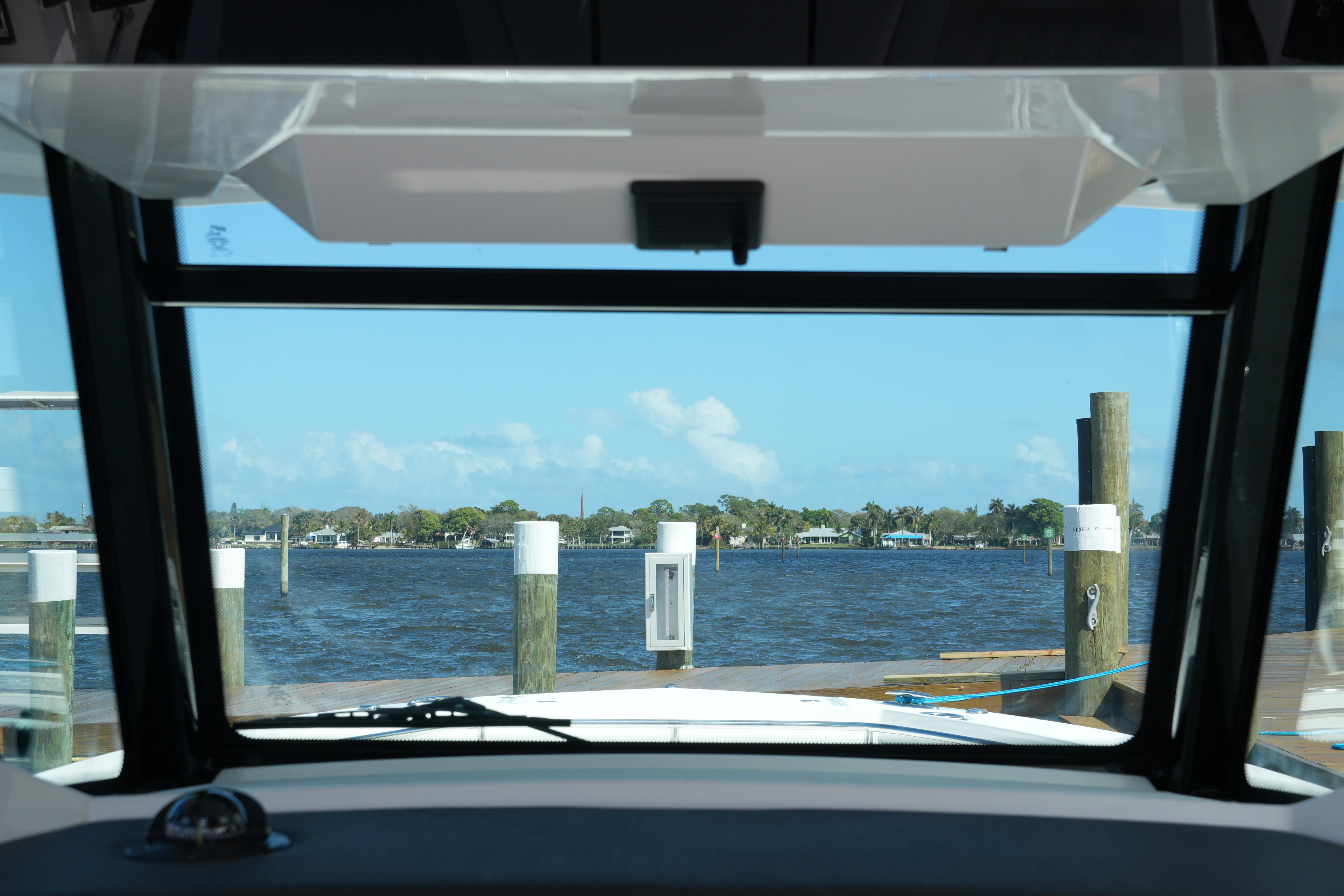 View from 2026 Blackfin 332 CC boat cockpit overlooking marina and calm waters.
