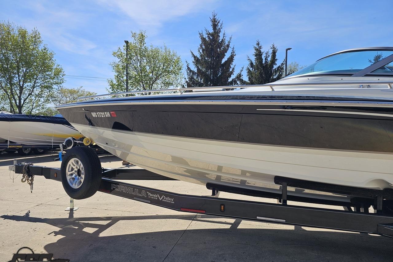 2014 Formula 292 FASTech boat on trailer, parked outdoors under clear sky.