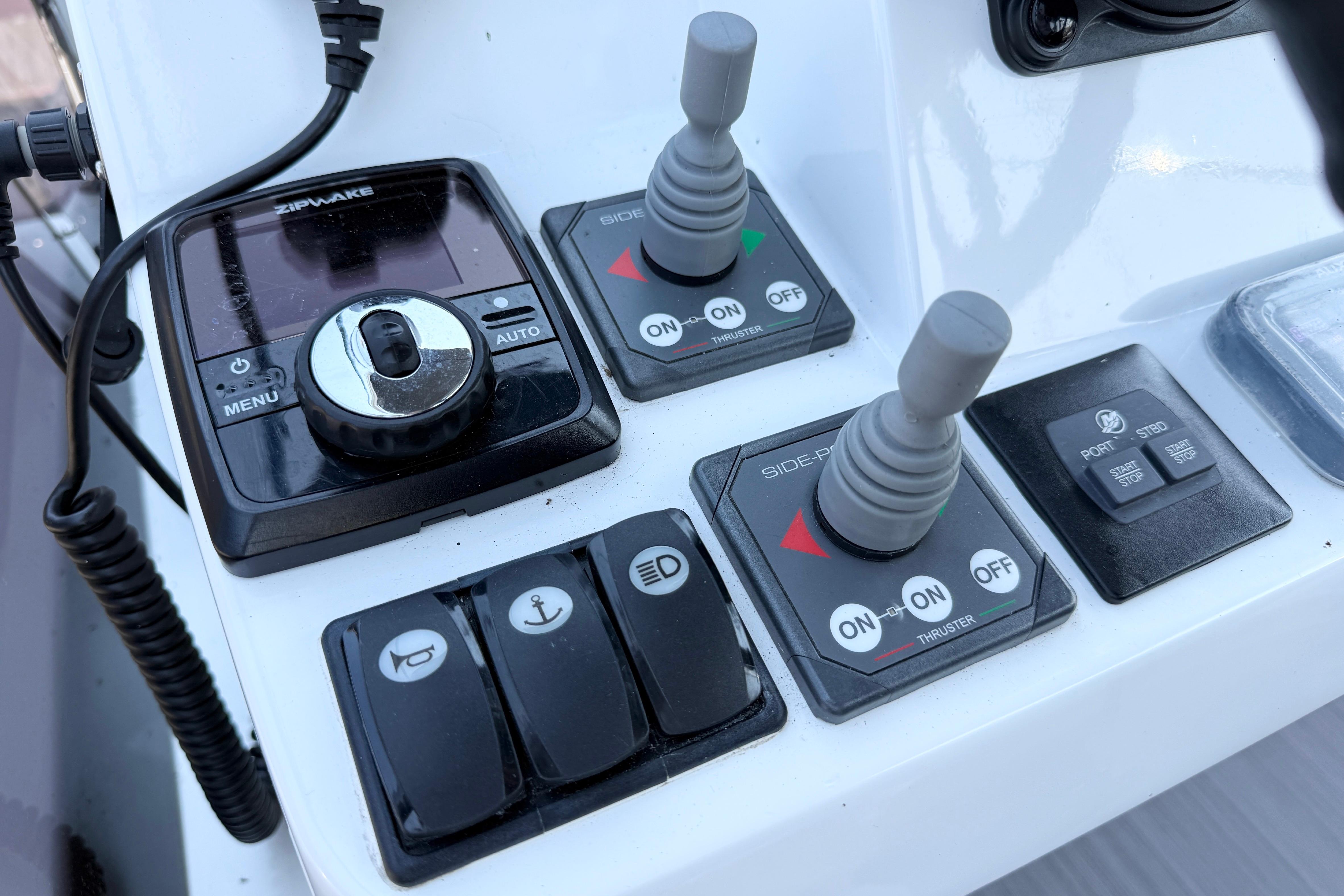 Control panel of a 2022 Jeanneau NC 1095 Fly boat with joysticks and switches.