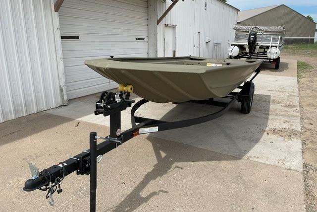 2026 Tracker Grizzly 1754 Utility boat on trailer, parked outside a garage.