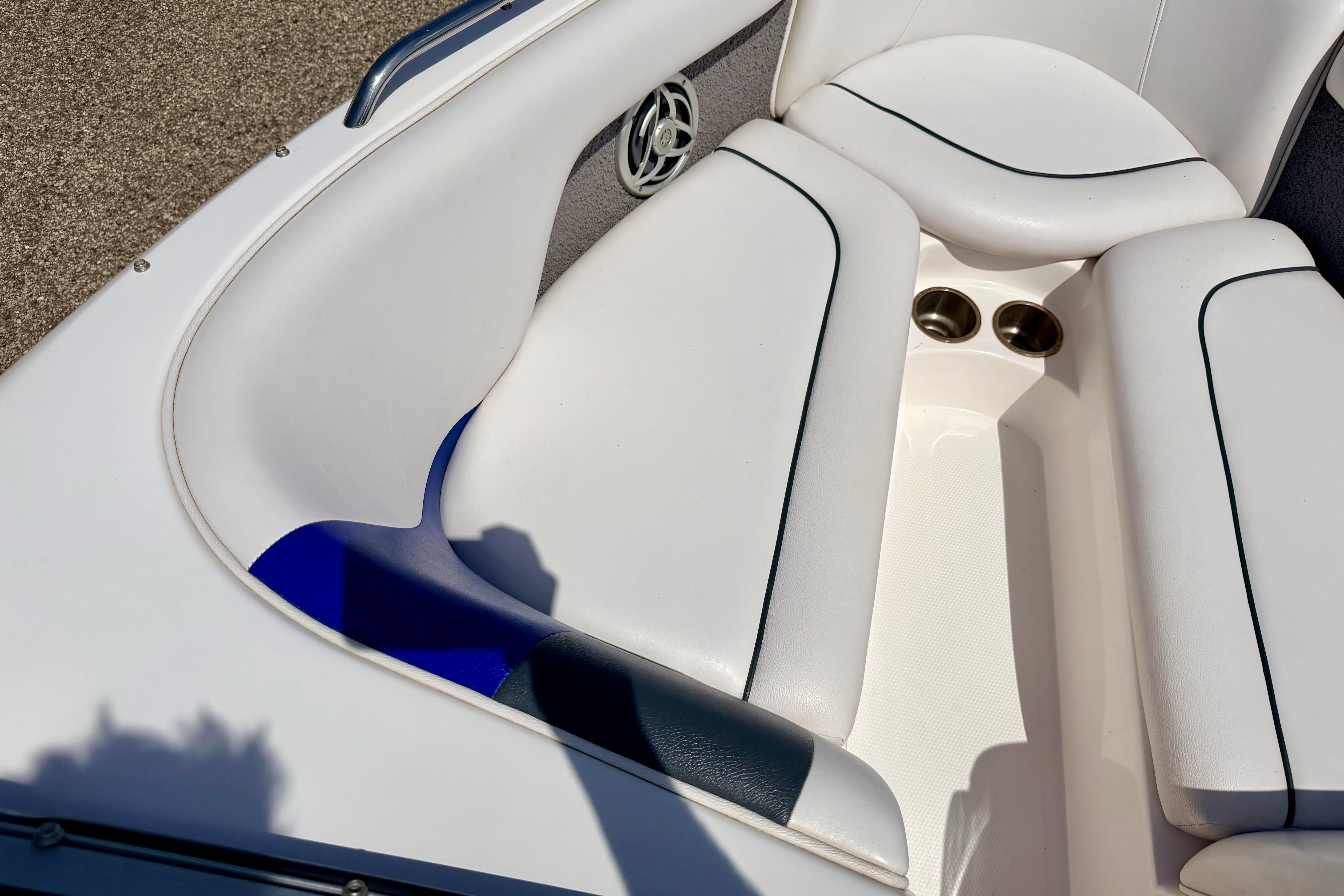 Interior seating of a 2008 Moomba Outback V boat with white upholstery and cup holders.