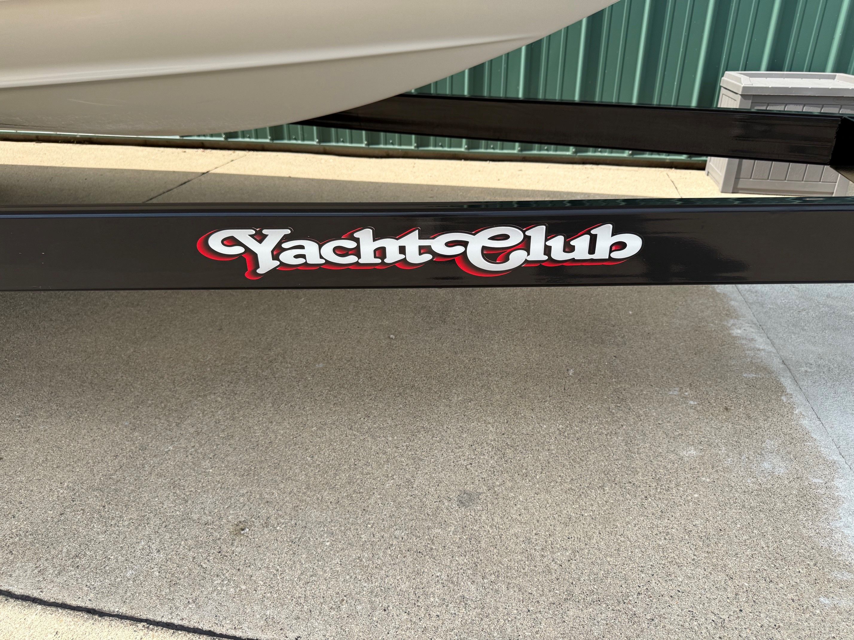 A boat trailer with "Yacht Club" written in red and white lettering.