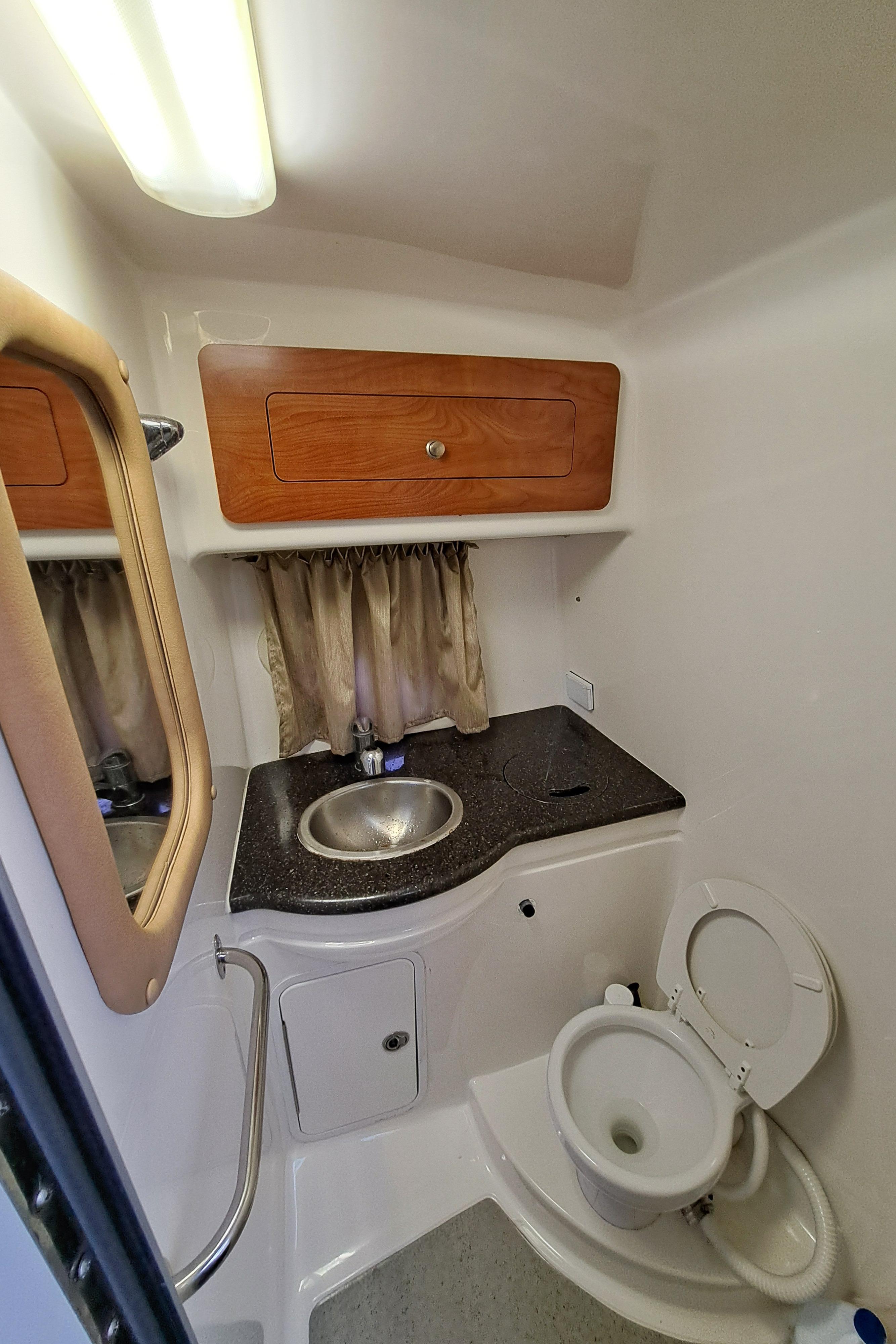 2013 Rinker 310 Express Cruiser bathroom with sink and toilet.