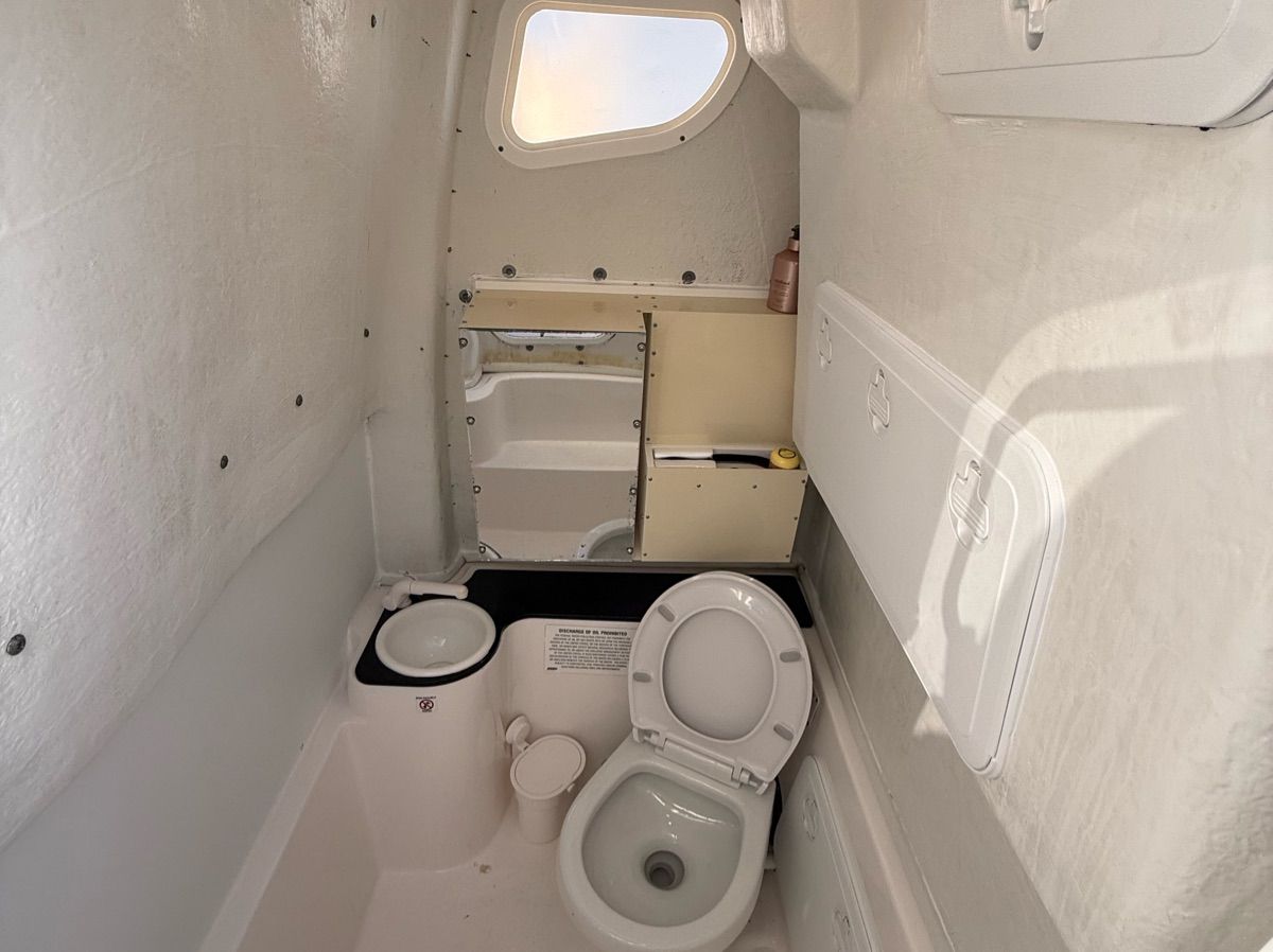 Interior of a boat cabin with a toilet and sink.