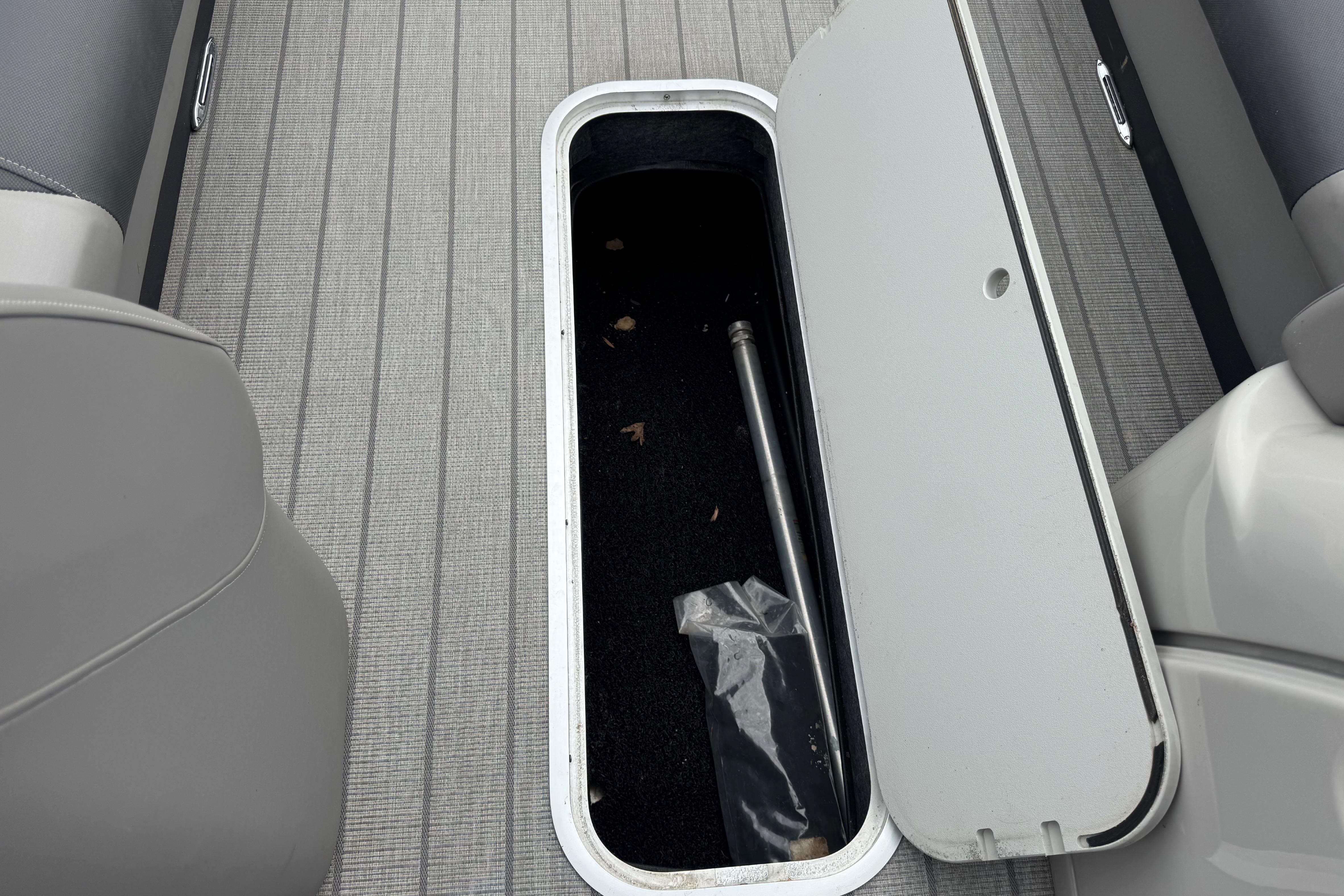 Open storage compartment on 2023 Starcraft MX 25 DL DH boat, revealing interior space.