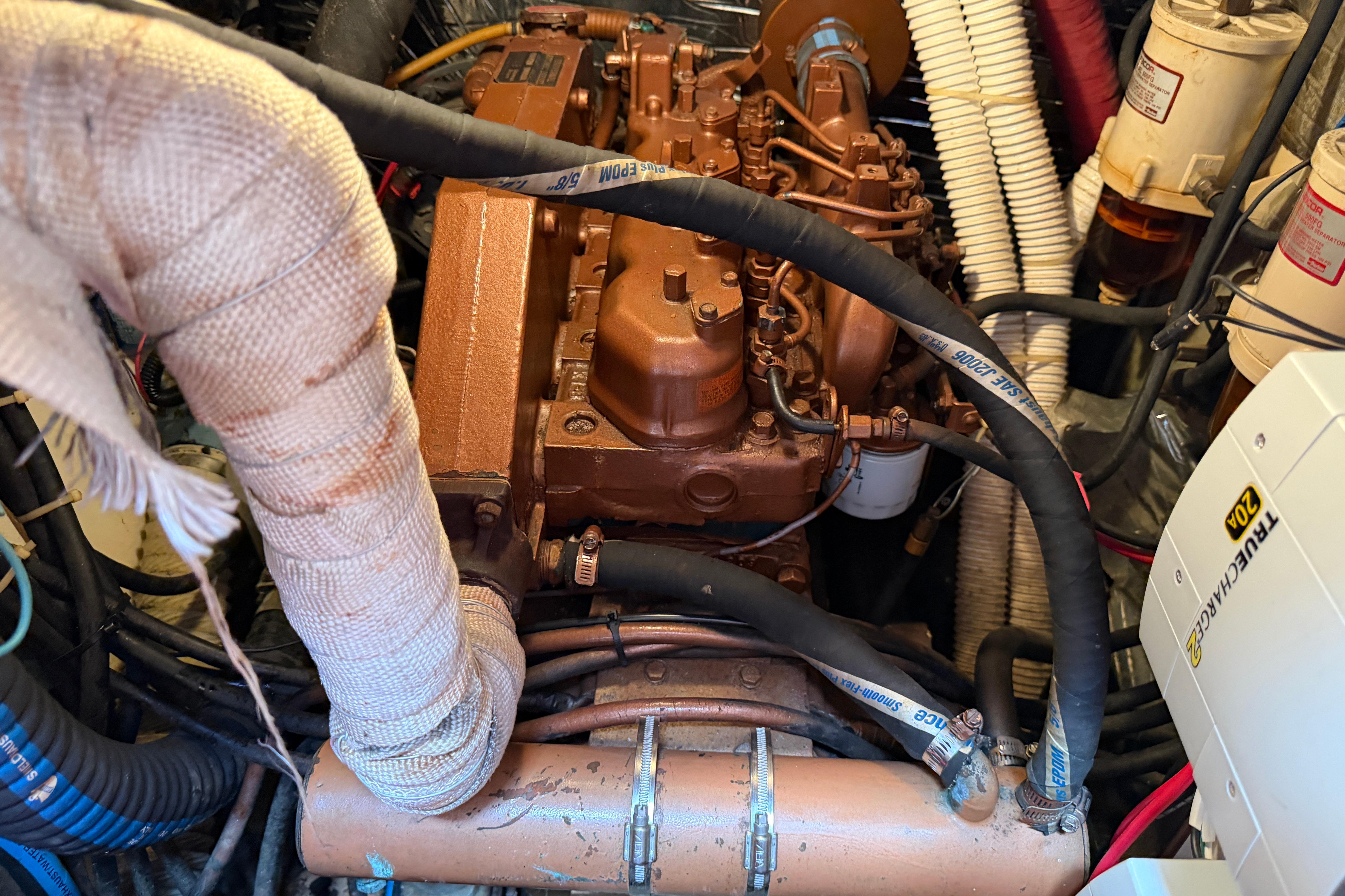 Engine compartment of a 1989 Nonsuch 36 sailboat, featuring various hoses and components.