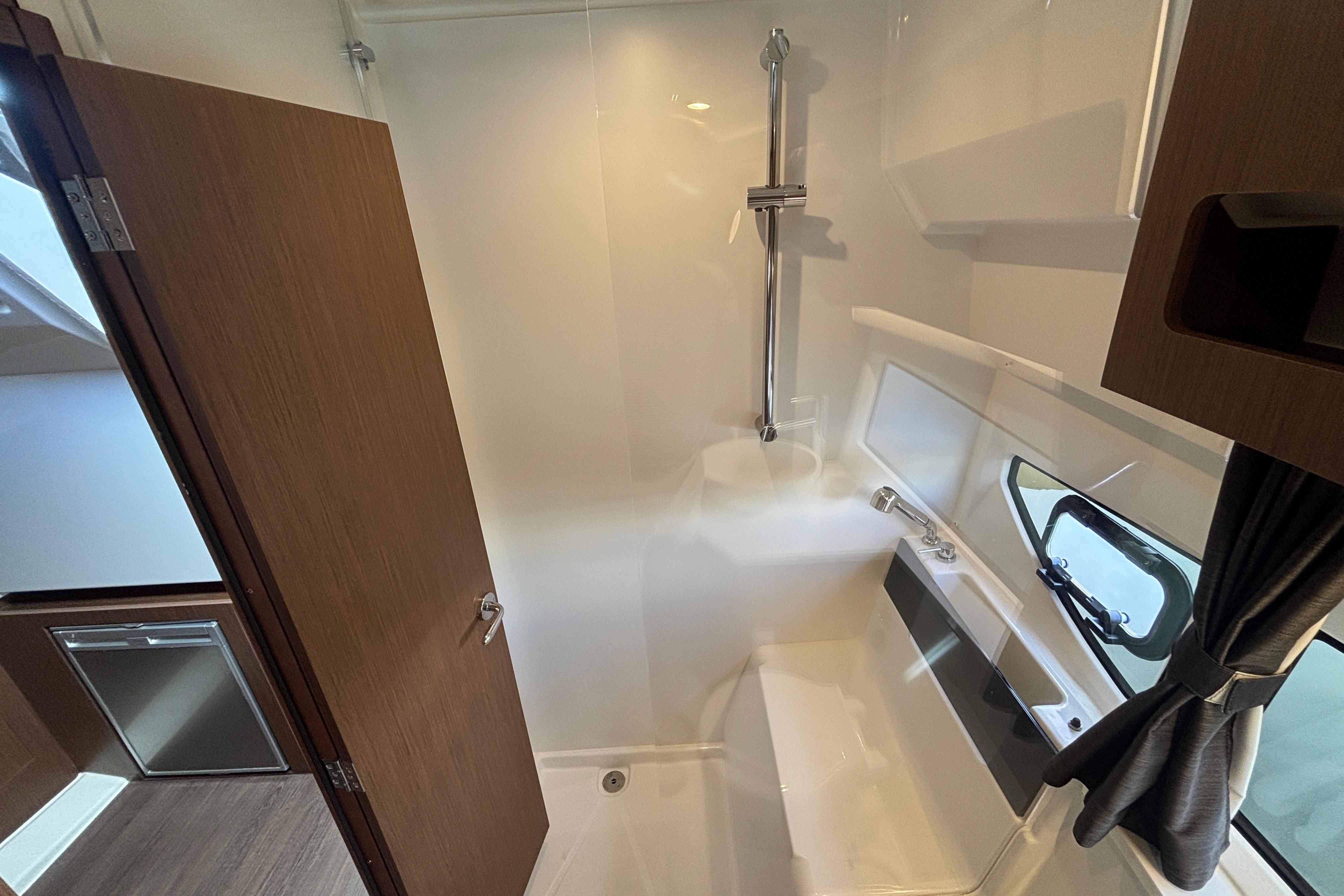 2024 Beneteau Antares 11 bathroom interior with shower and window.